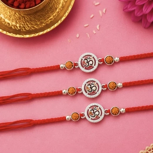 Estele rhodium-plated bracelets feature a red enamel Om symbol and fancy silk thread