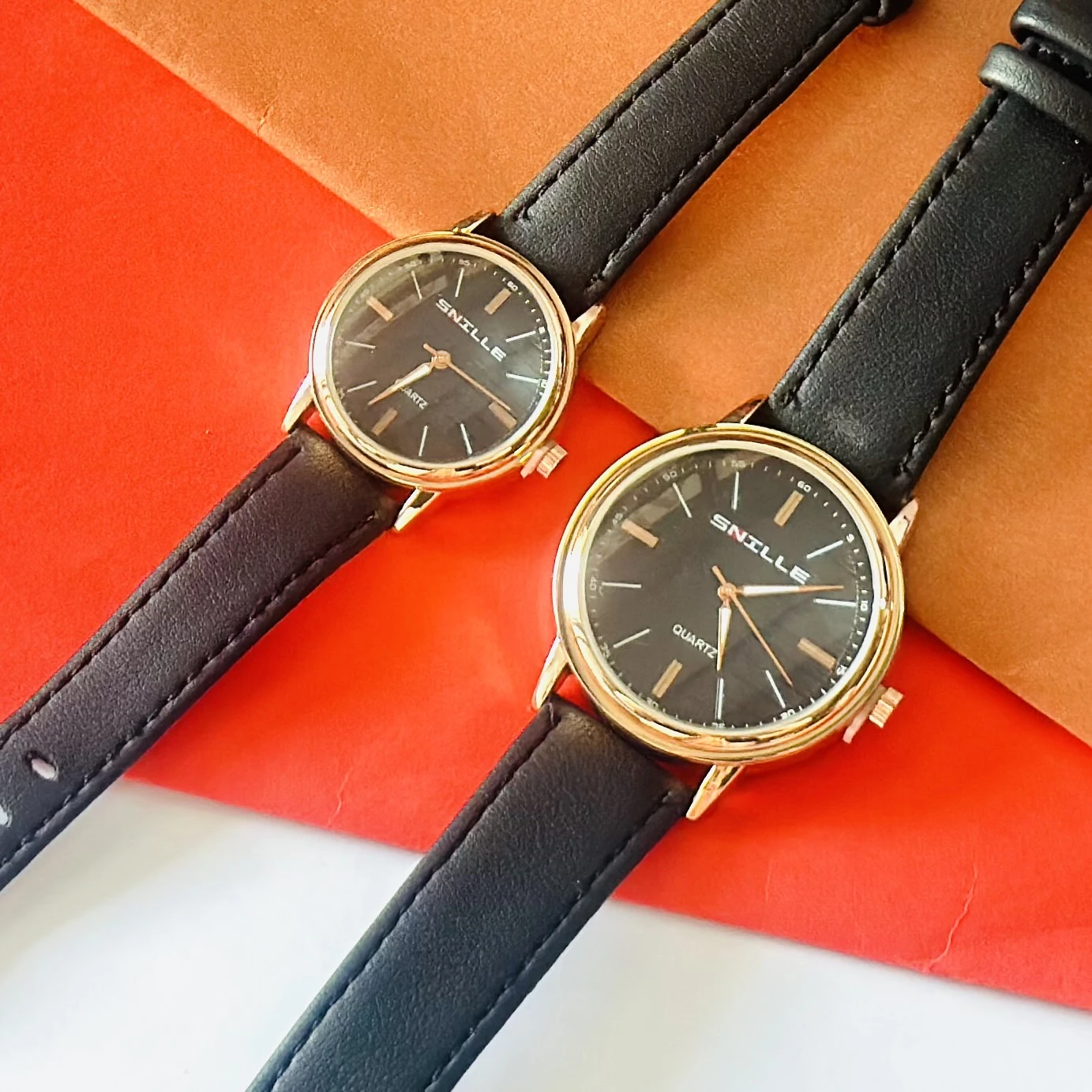 black "Snille" quartz watches with gold-tone cases and black faux leather straps