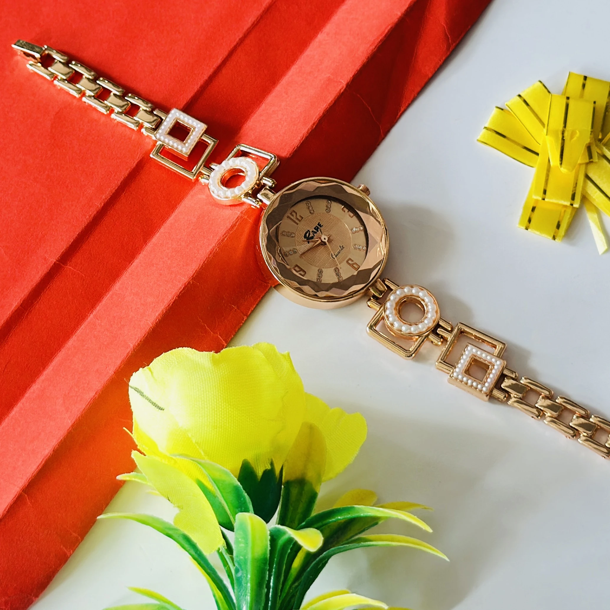 women's analog wristwatch featuring a rose gold-colored chain strap and a stylized dial.