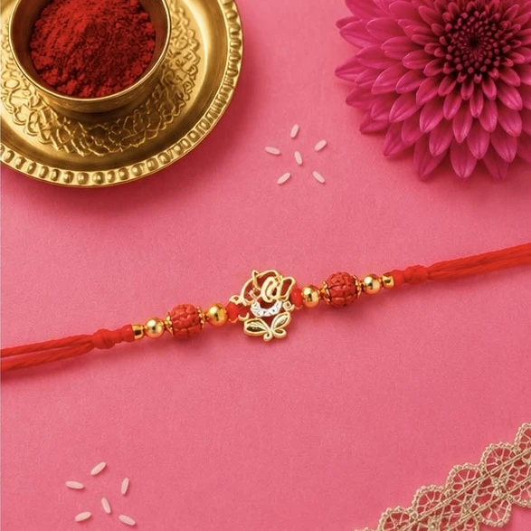 Ganesha Rakhi featuring a gold-plated Lord Ganesha pendant on a red mauli thread.