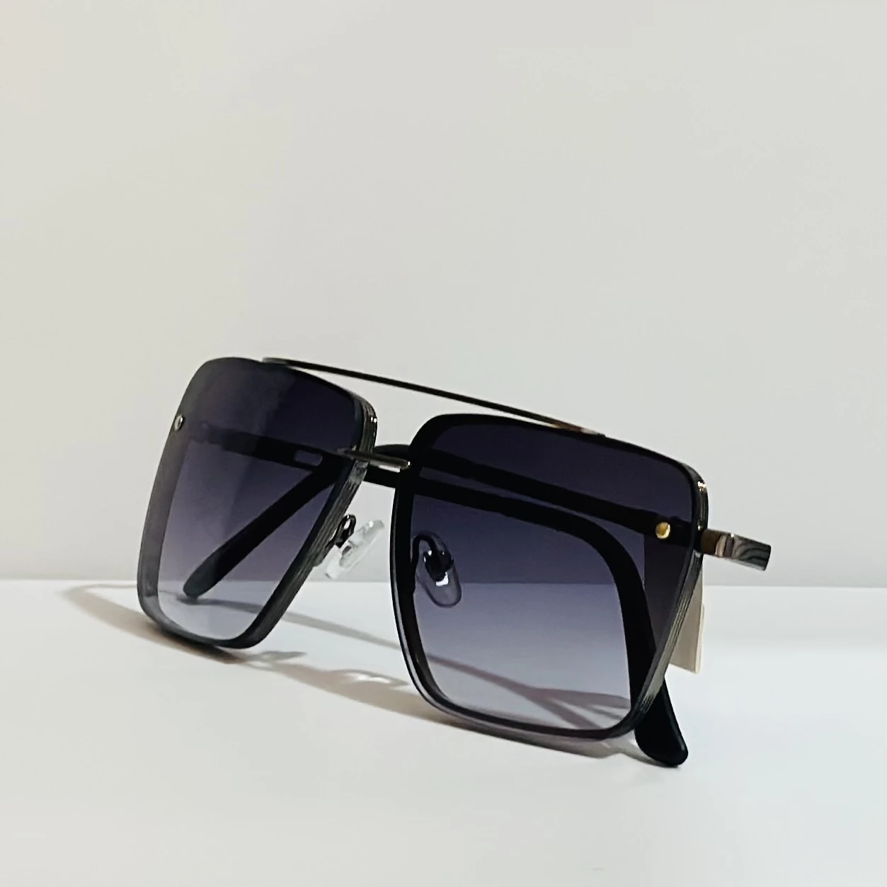 pair of square aviator sunglasses with a black metal frame and gradient lenses.