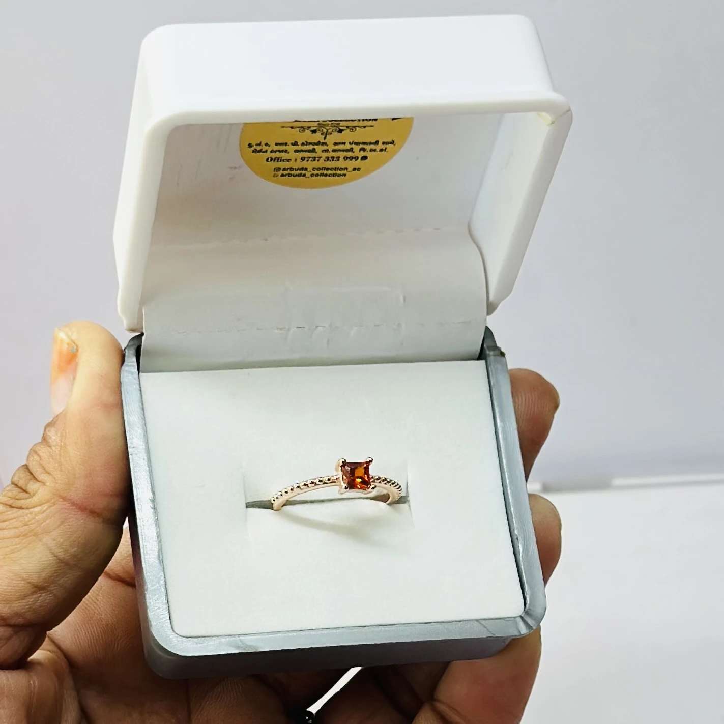 sterling silver ring with a rectangular orange gemstone, possibly hessonite garnet or citrine.