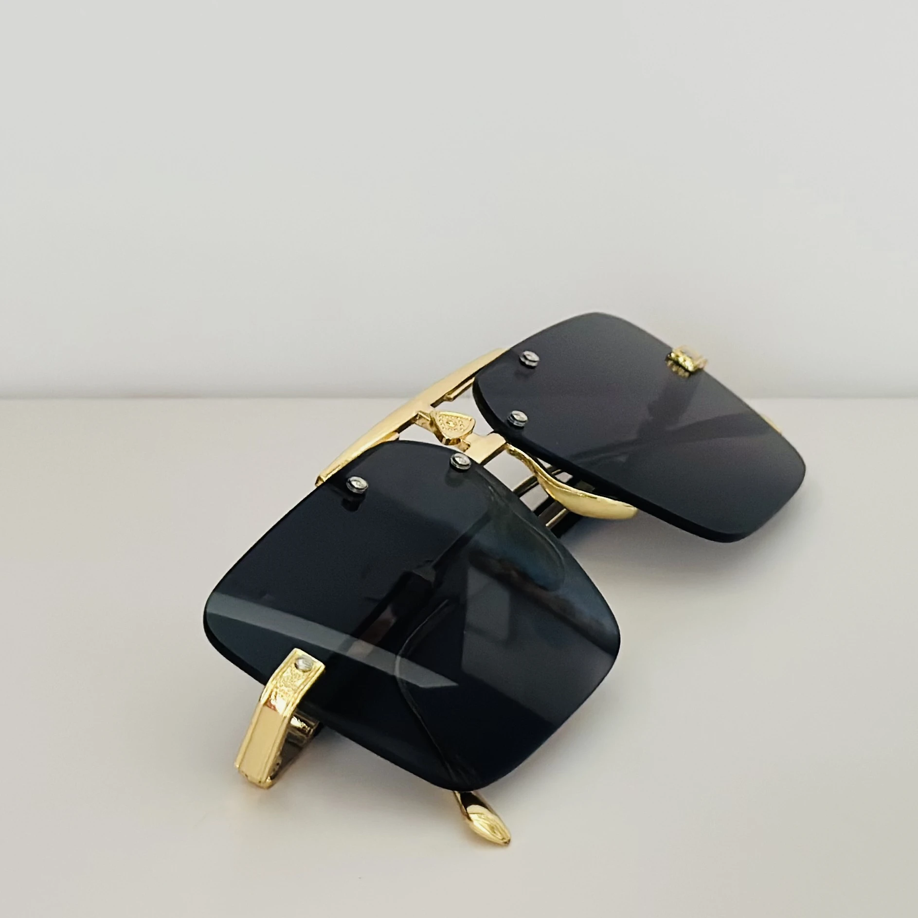 Maybach square gold-framed sunglasses with black lenses.