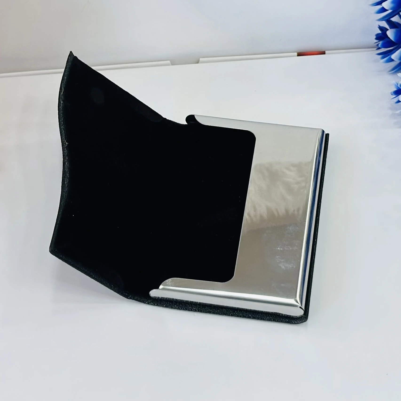 black faux leather and metal business card holder.