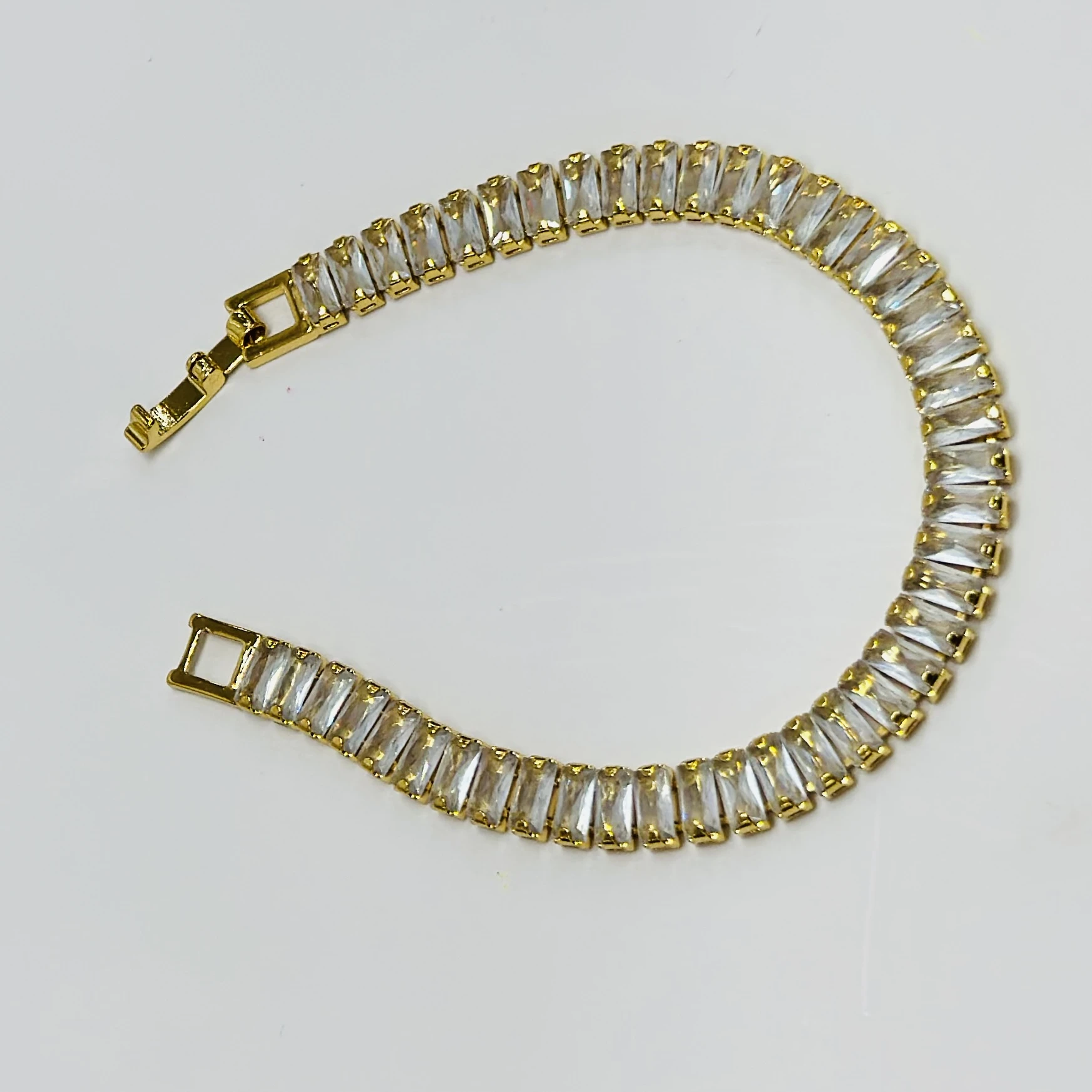 Gold plated black baguette tennis bracelet with artificial stones.