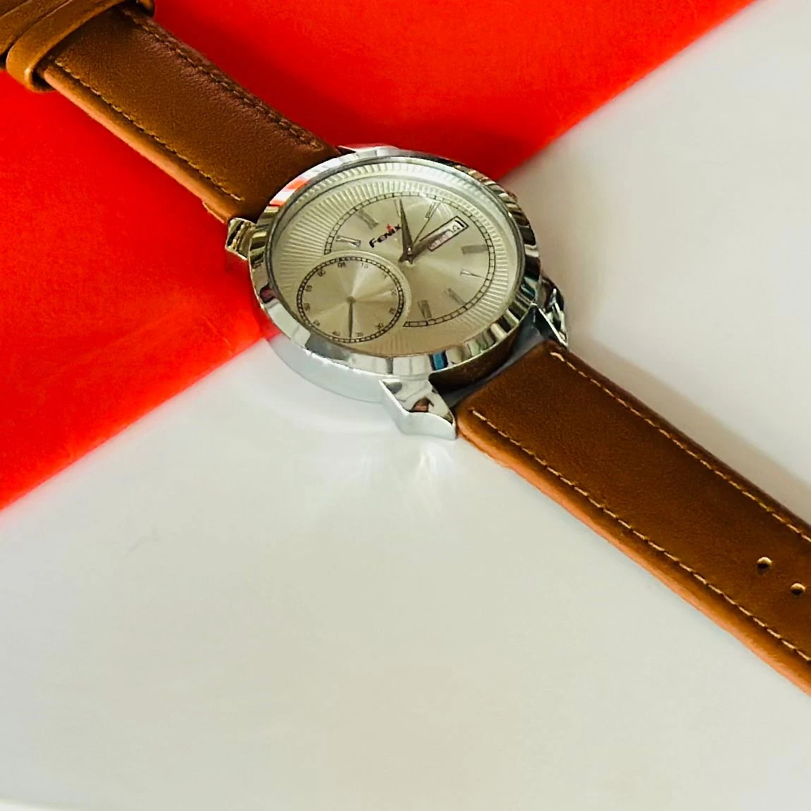 Round analog watch with a brown leather strap