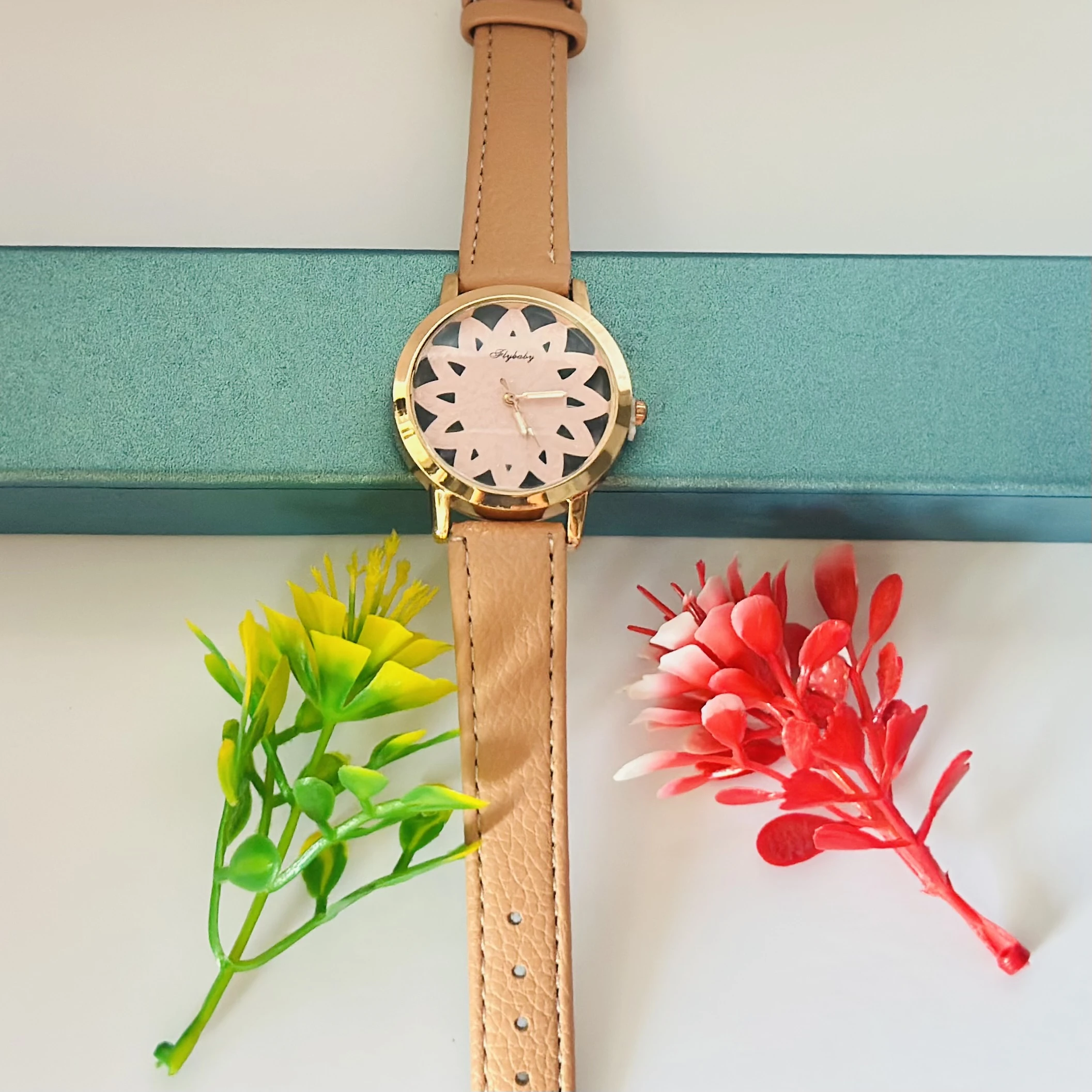 Flybaby flower watch with a peach/tan faux leather strap.