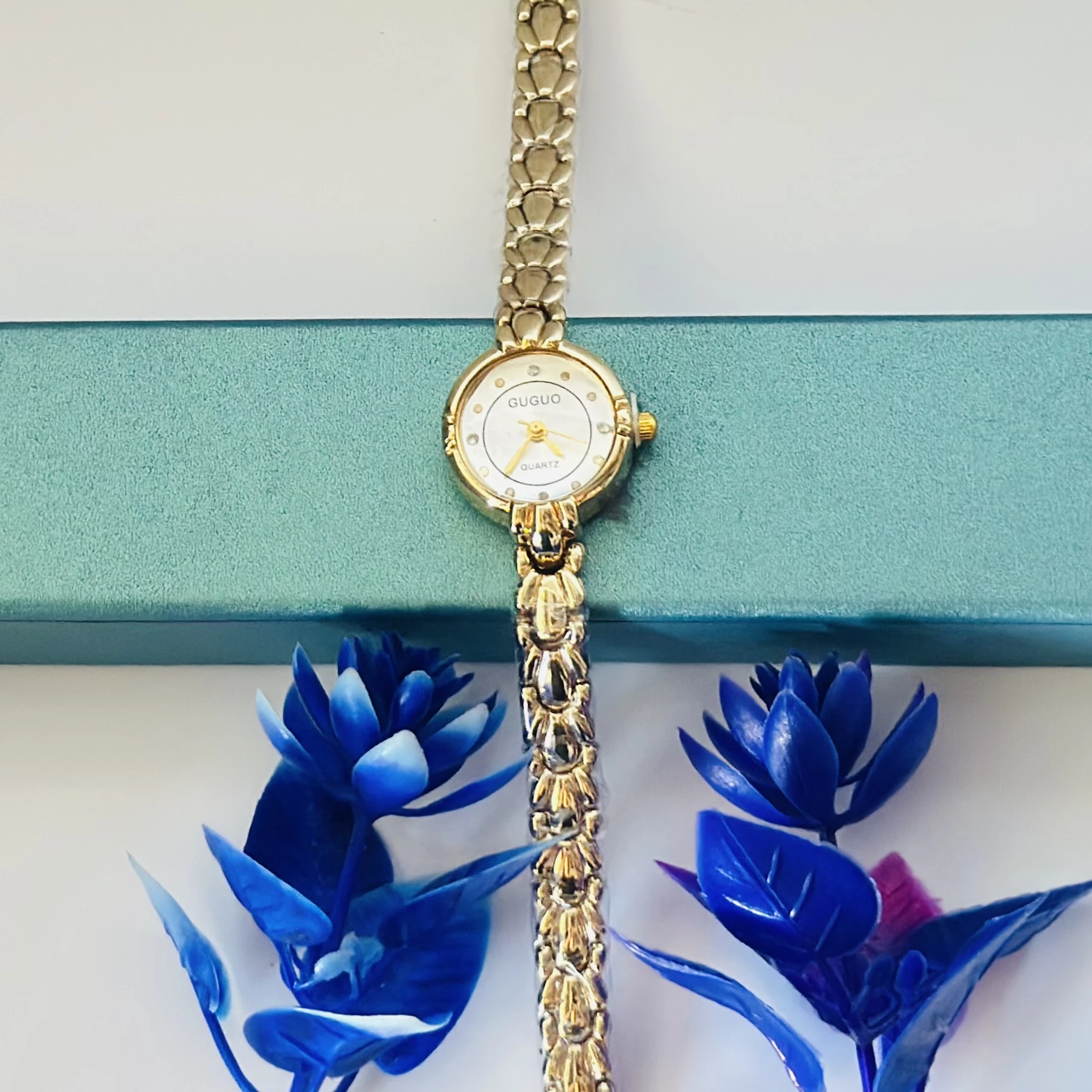 gold-tone GUGUO quartz choker watch with a round white face.