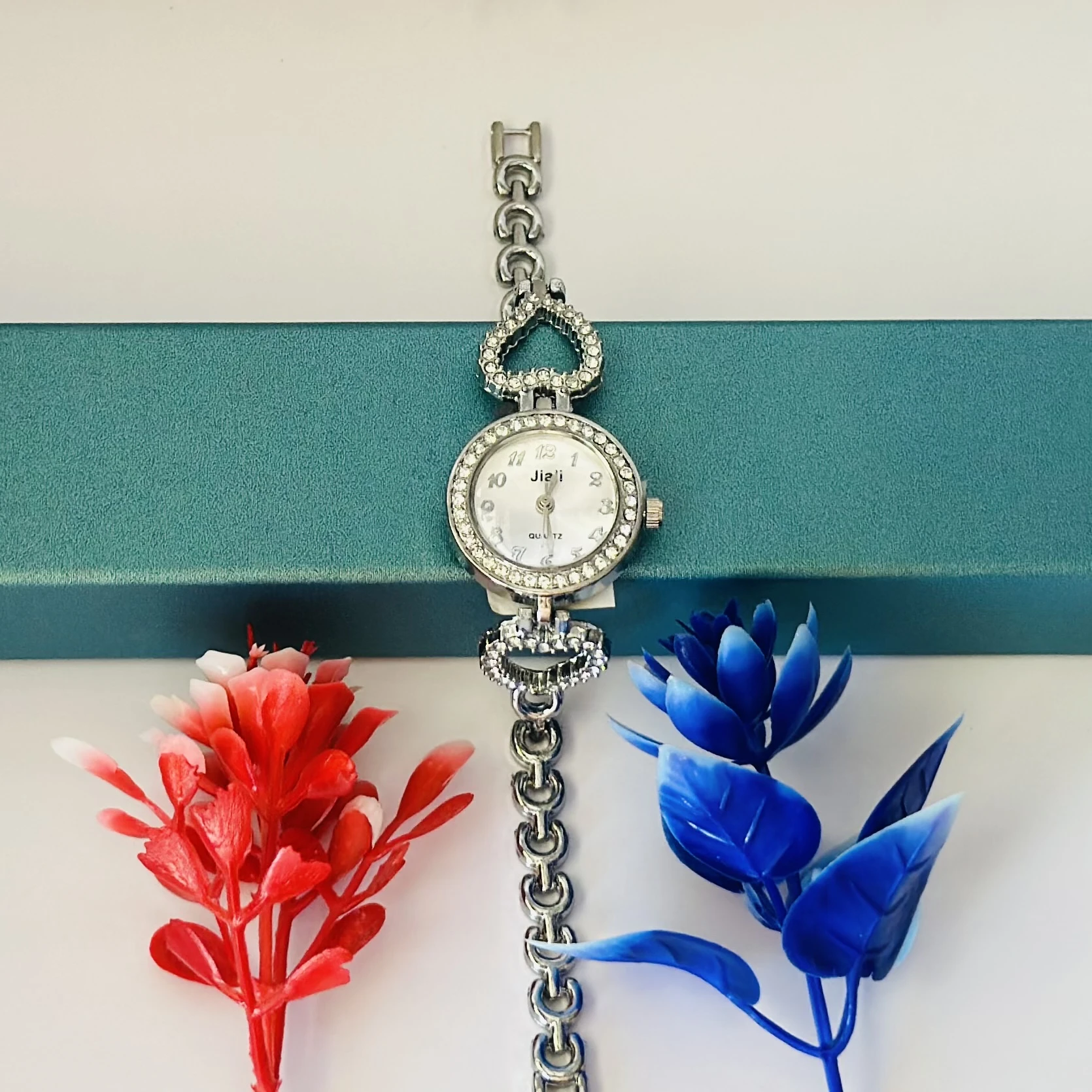 Women’s watch with a silver metal bracelet and crystal-studded bezel.