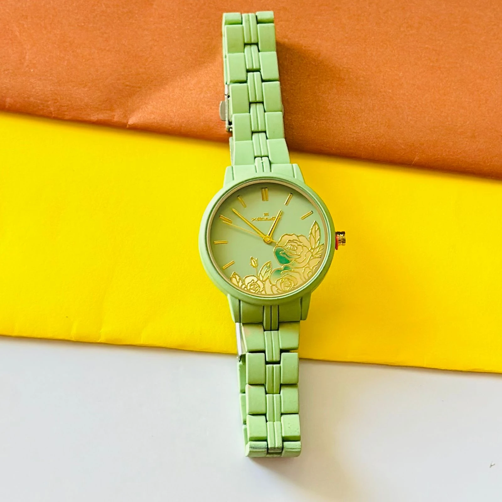 light green women's analog watch with a floral print on the dial and a link bracelet.