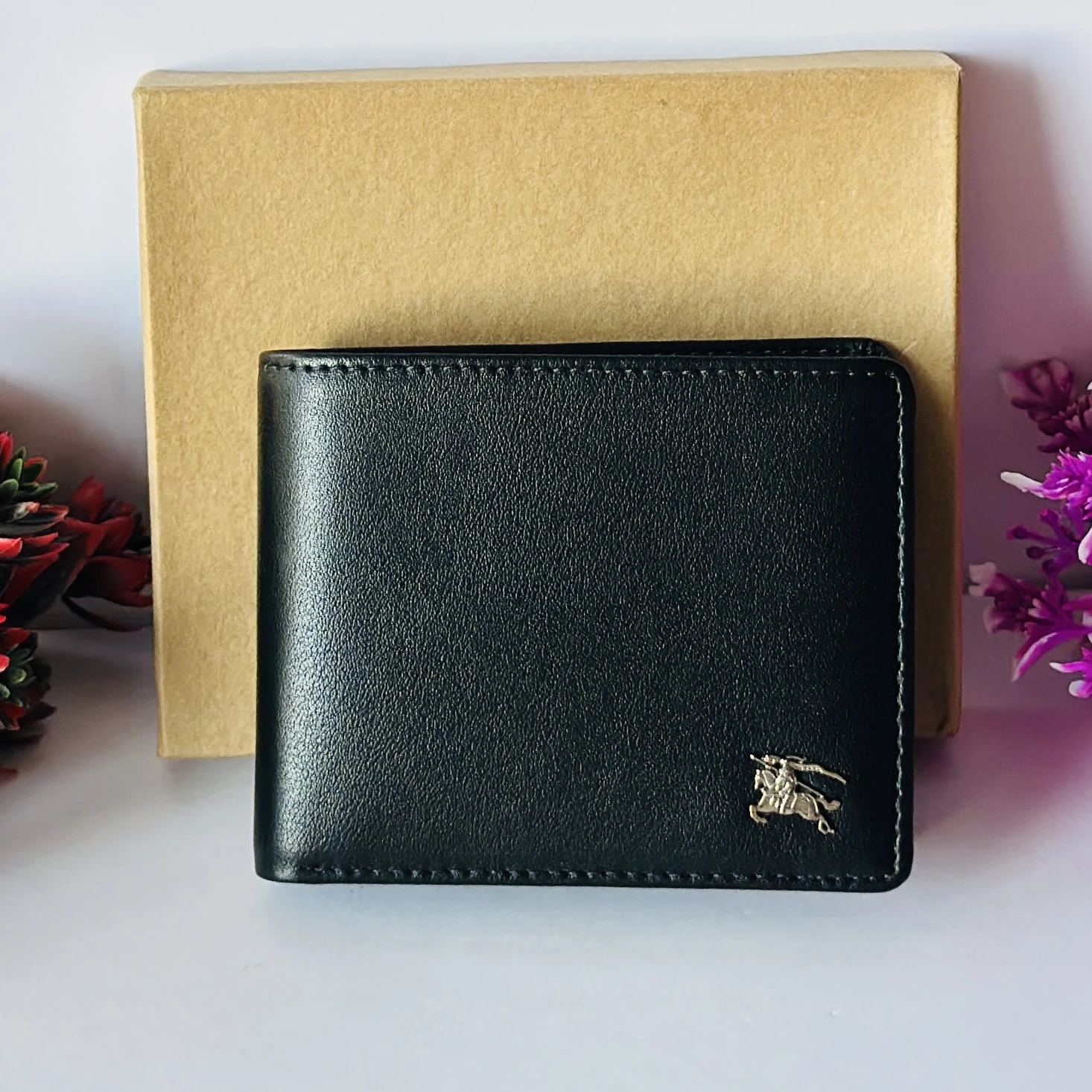 Black bifold leather wallet with a metal logo accent.