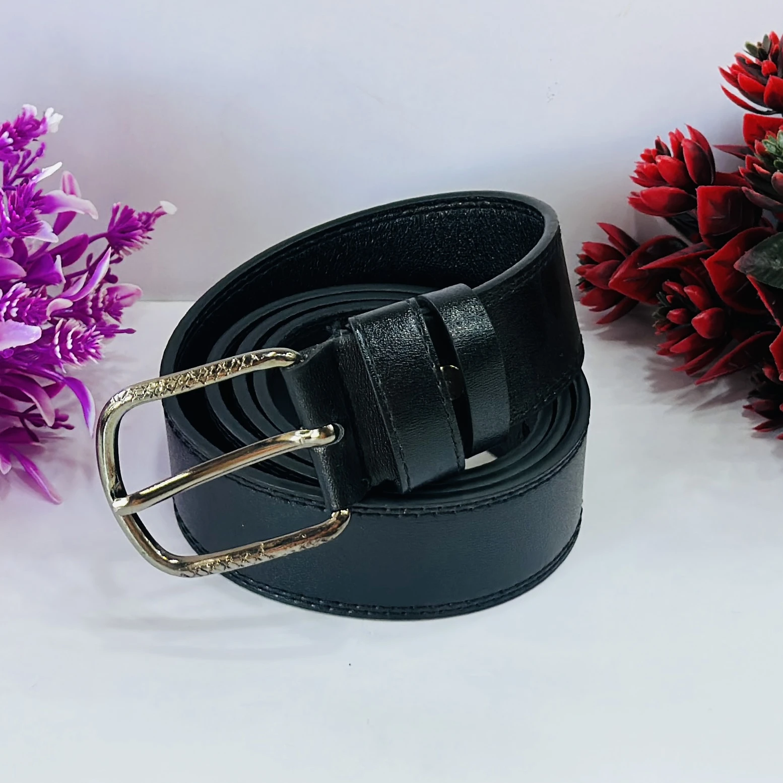 Men’s black leather belt with a metal buckle.