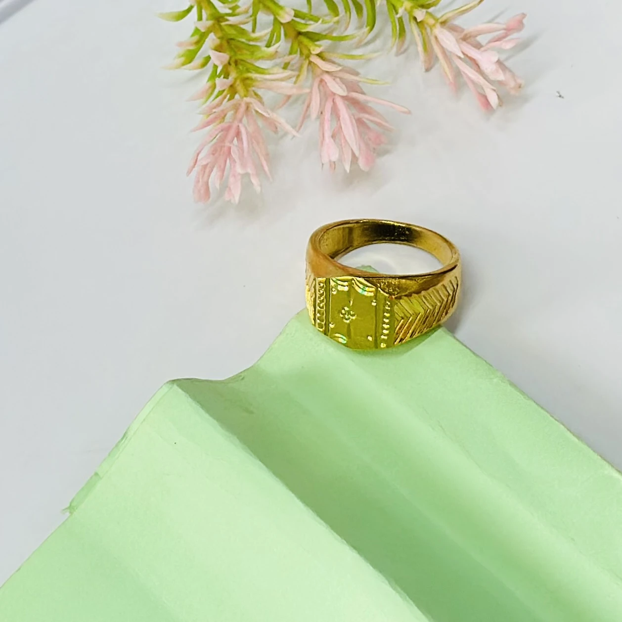 Gold toned signet ring with engraved detailing.