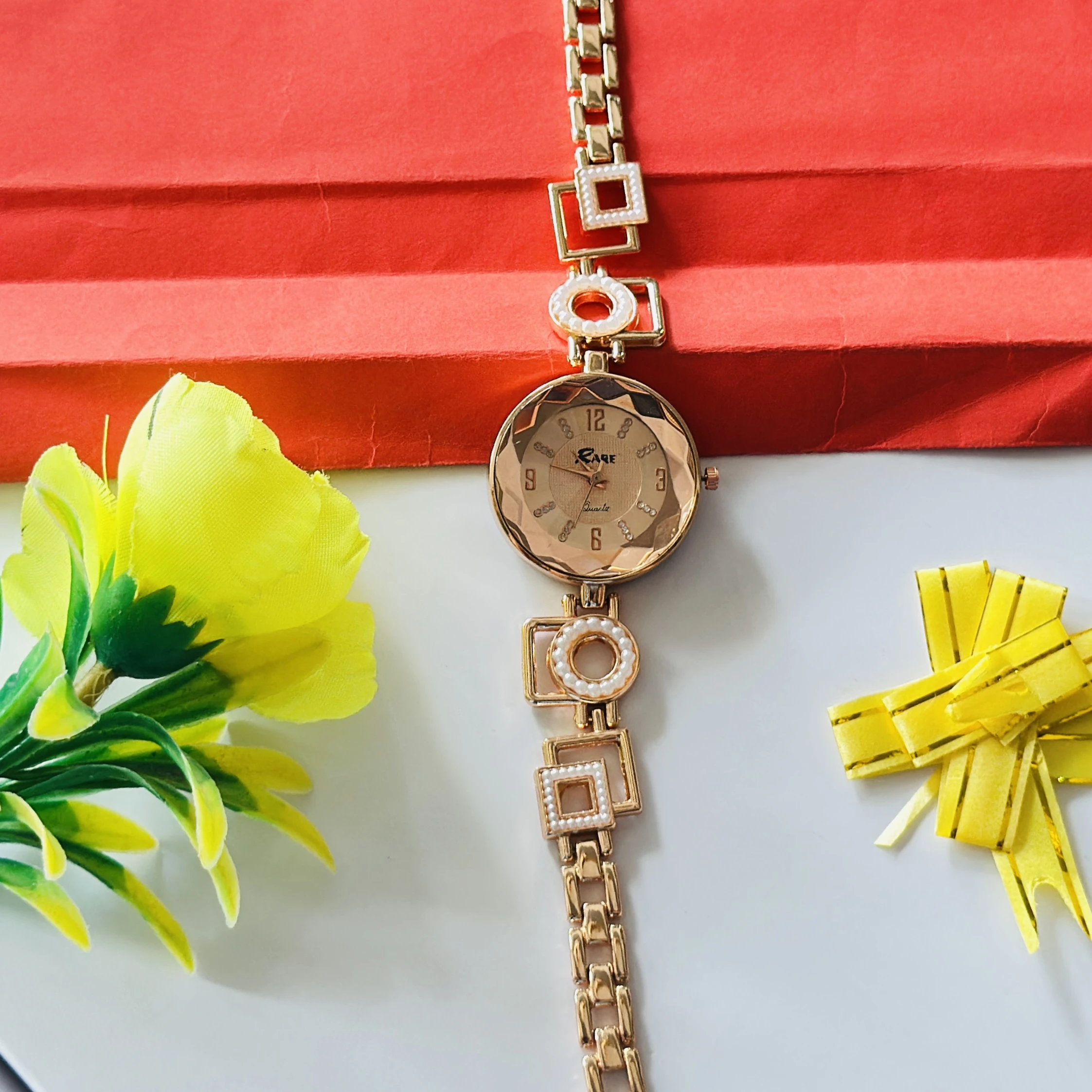 women's analog wristwatch featuring a rose gold-colored chain strap and a stylized dial.