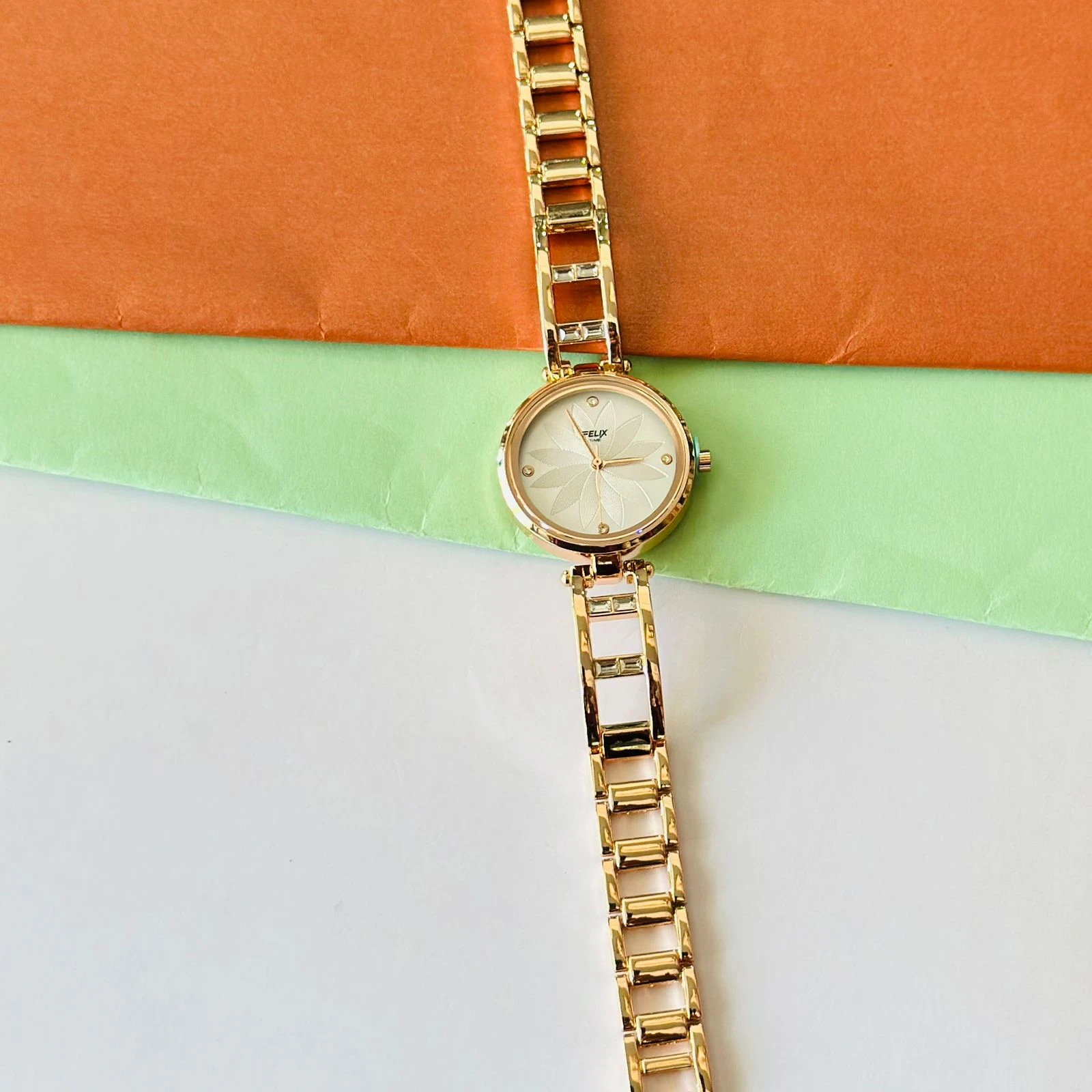 analog watch with a white dial and a rose gold metal strap