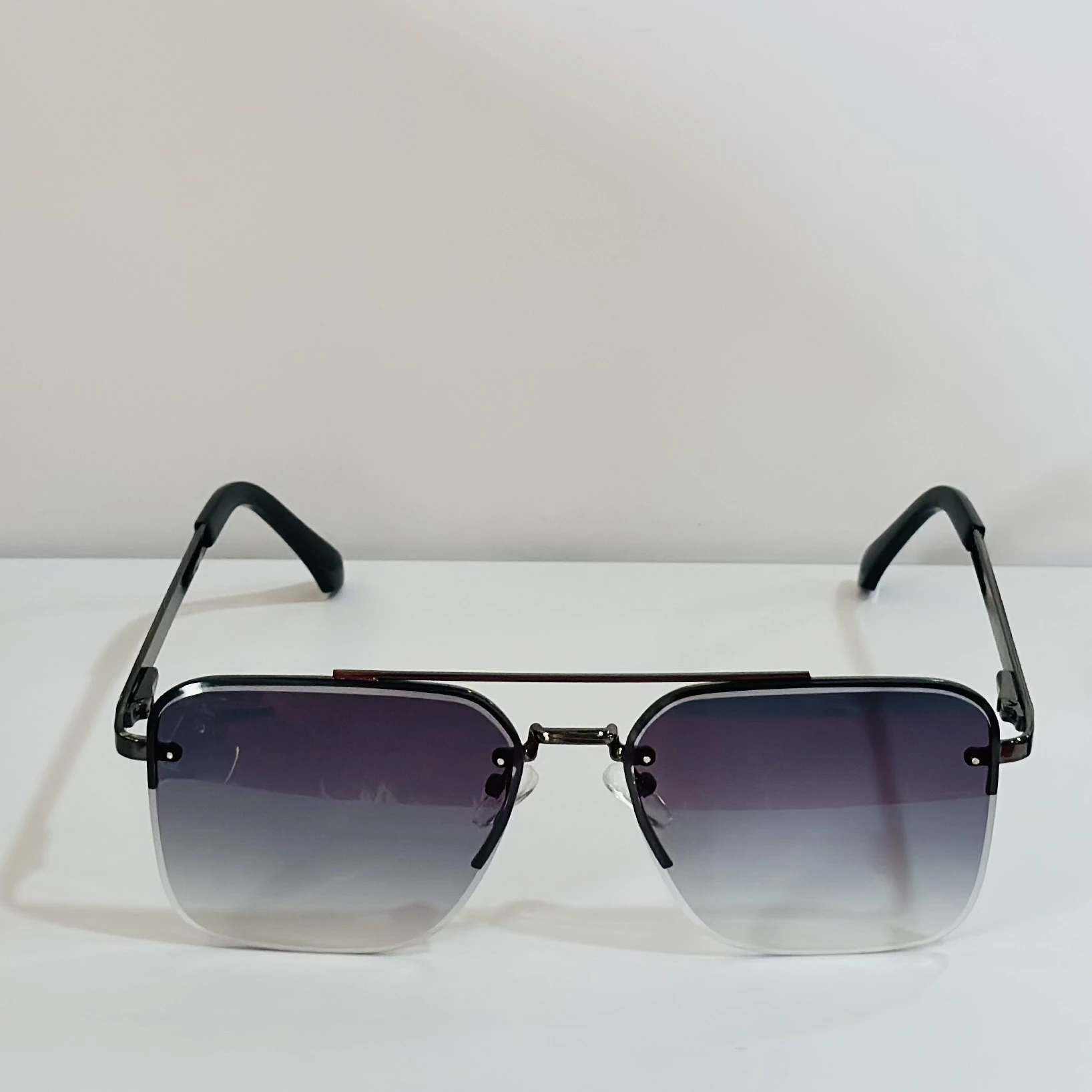 pair of aviator-style sunglasses with a black metal frame and grey gradient lenses.