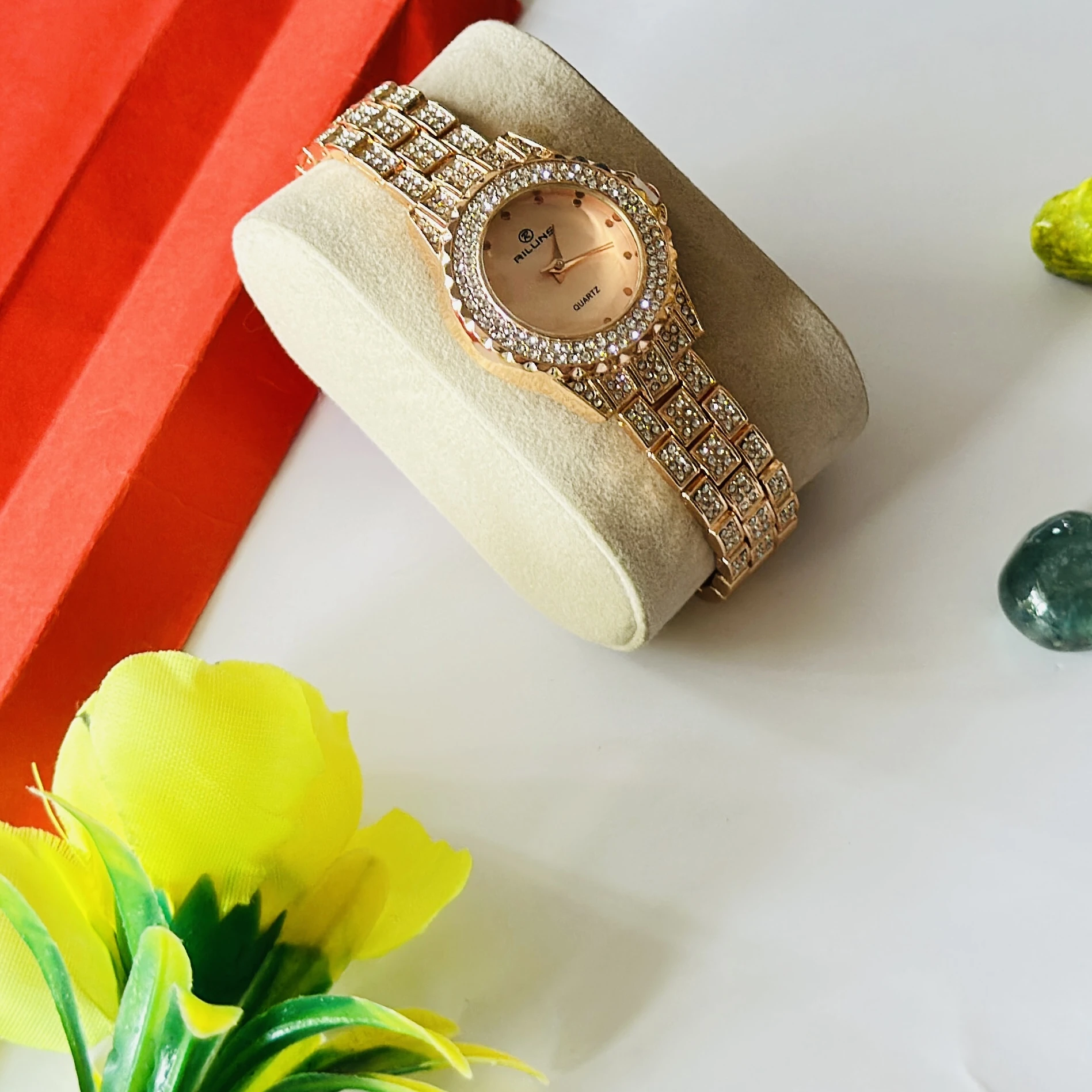 Riluns branded quartz watch featuring a rose gold finish and rhinestone embellishments.
