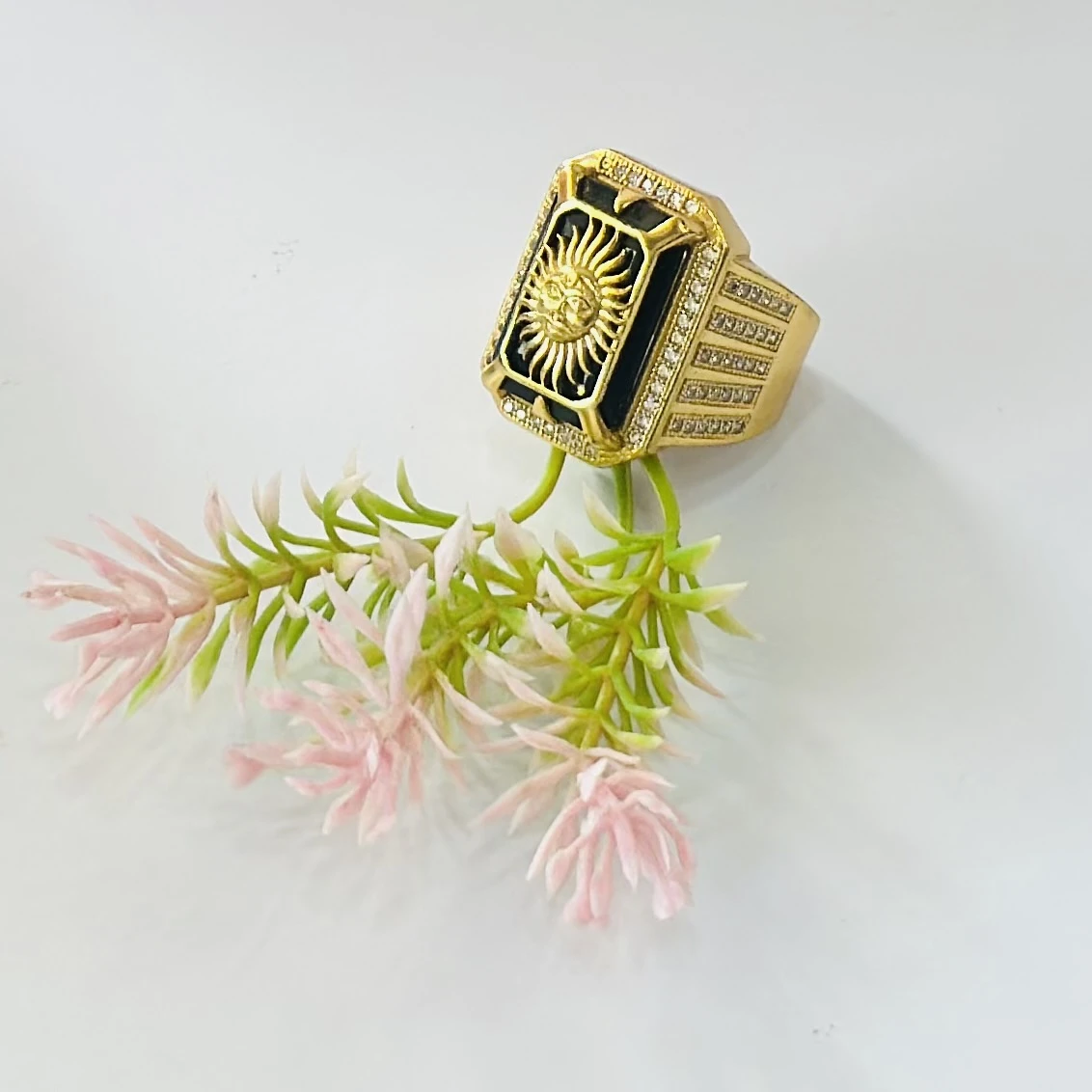 Gold plated men's ring featuring a sun emblem on a black background
