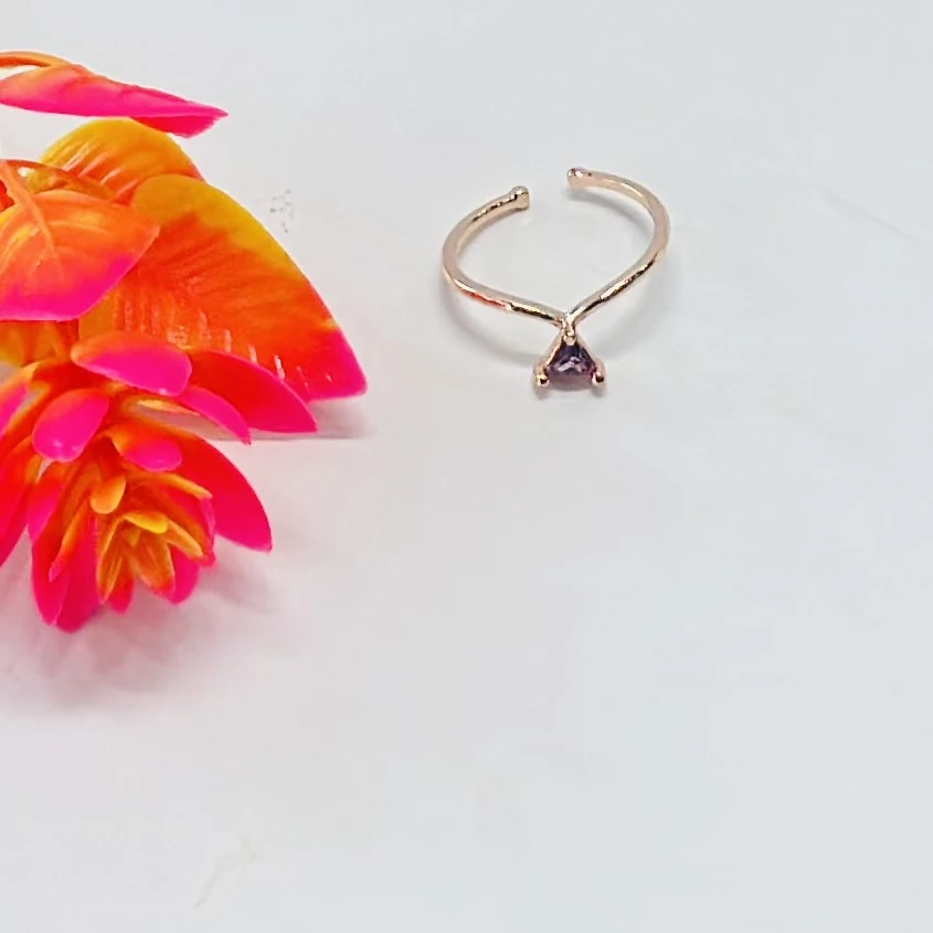 An adjustable bypass ring with a trillion cut amethyst stone.