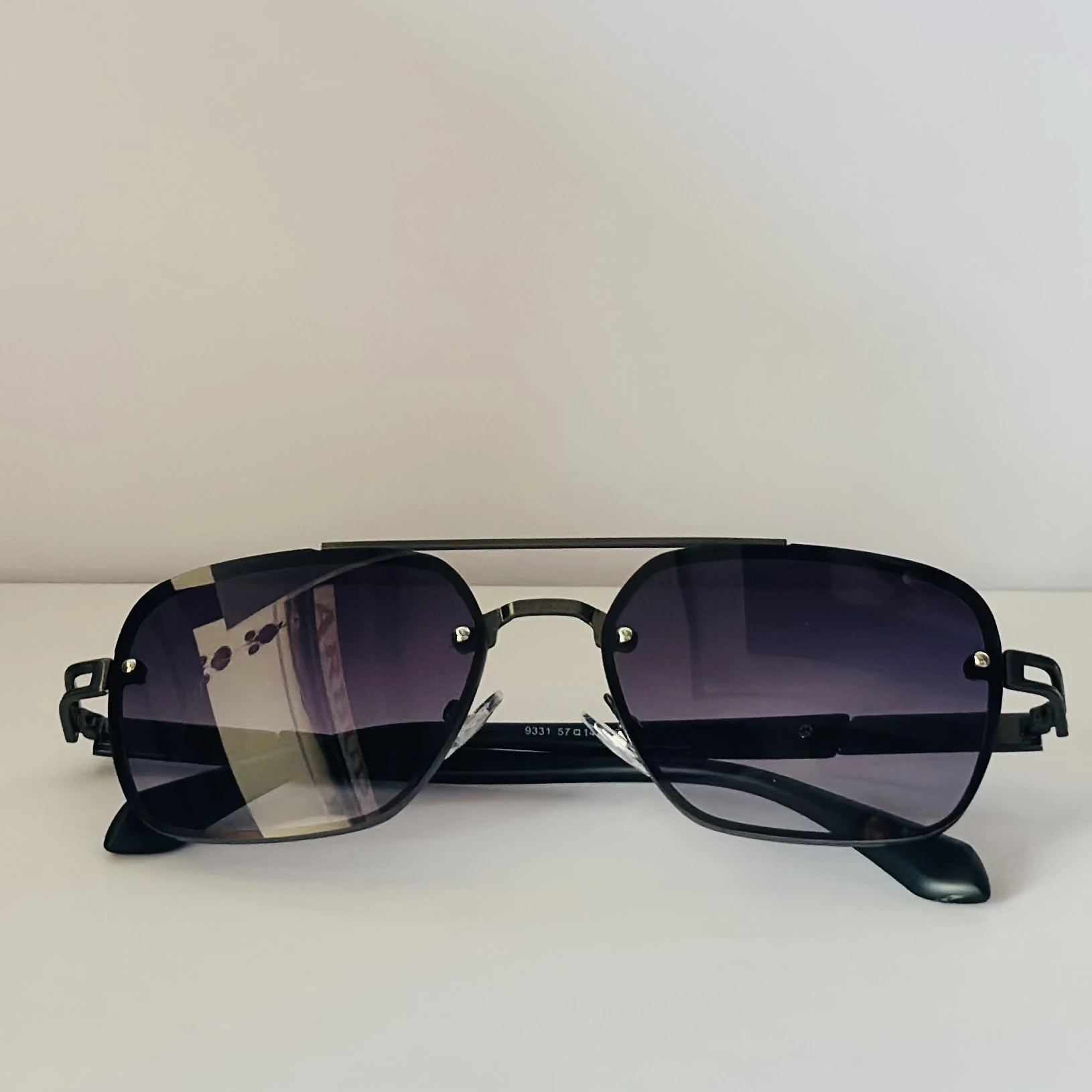 pair of Maybach square-style sunglasses with a black metal frame and dark gradient lenses
