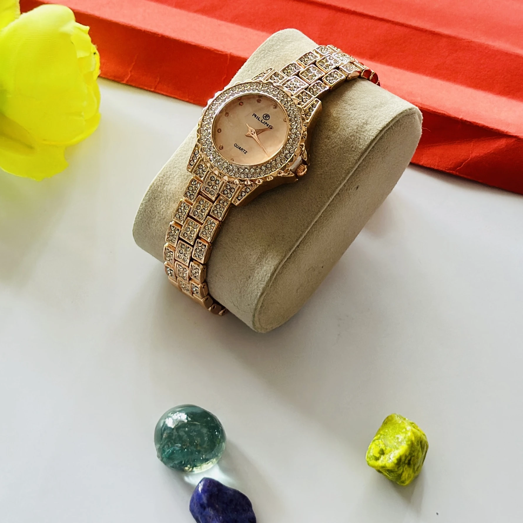 Riluns branded quartz watch featuring a rose gold finish and rhinestone embellishments.