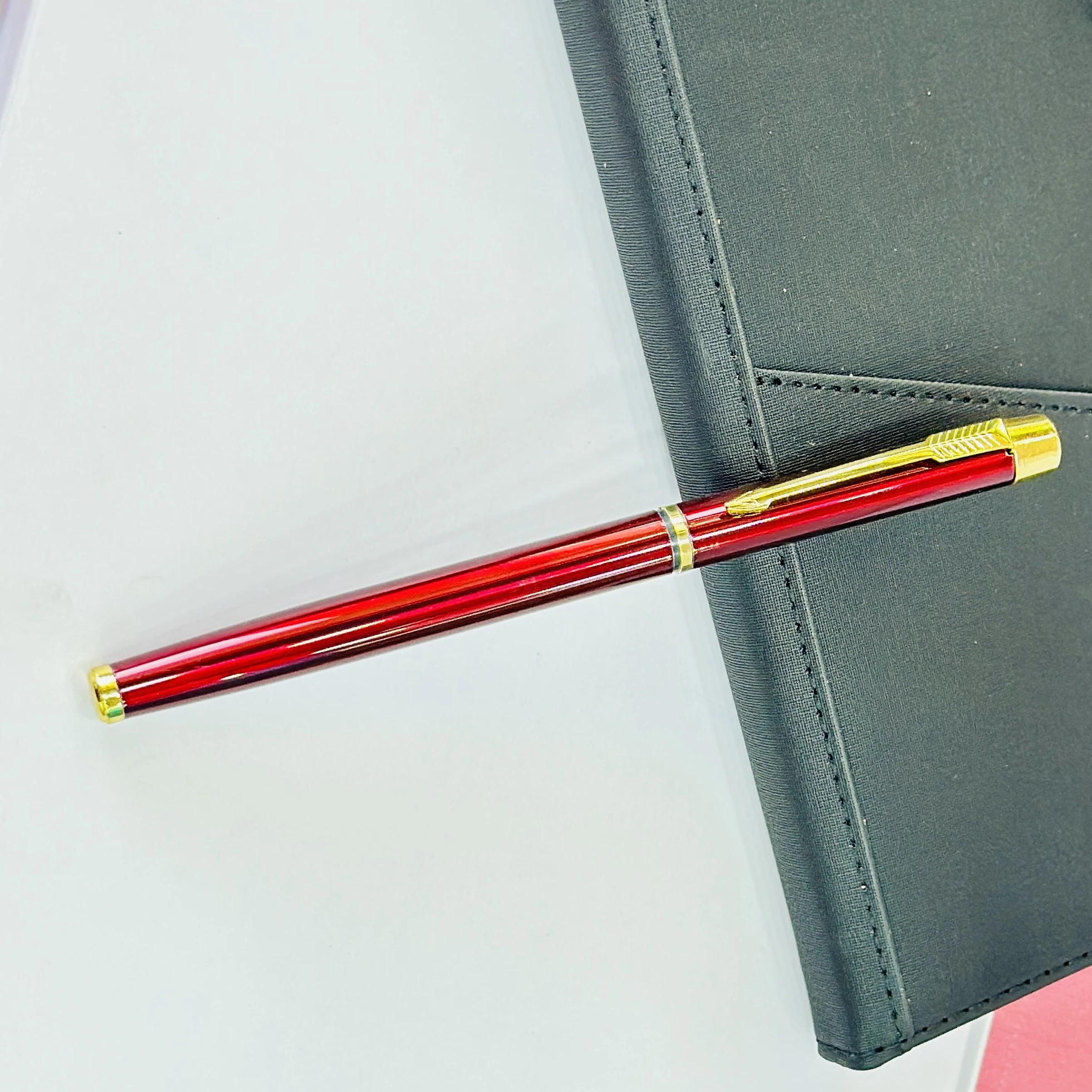 sleek maroon and gold metal rollerball pen