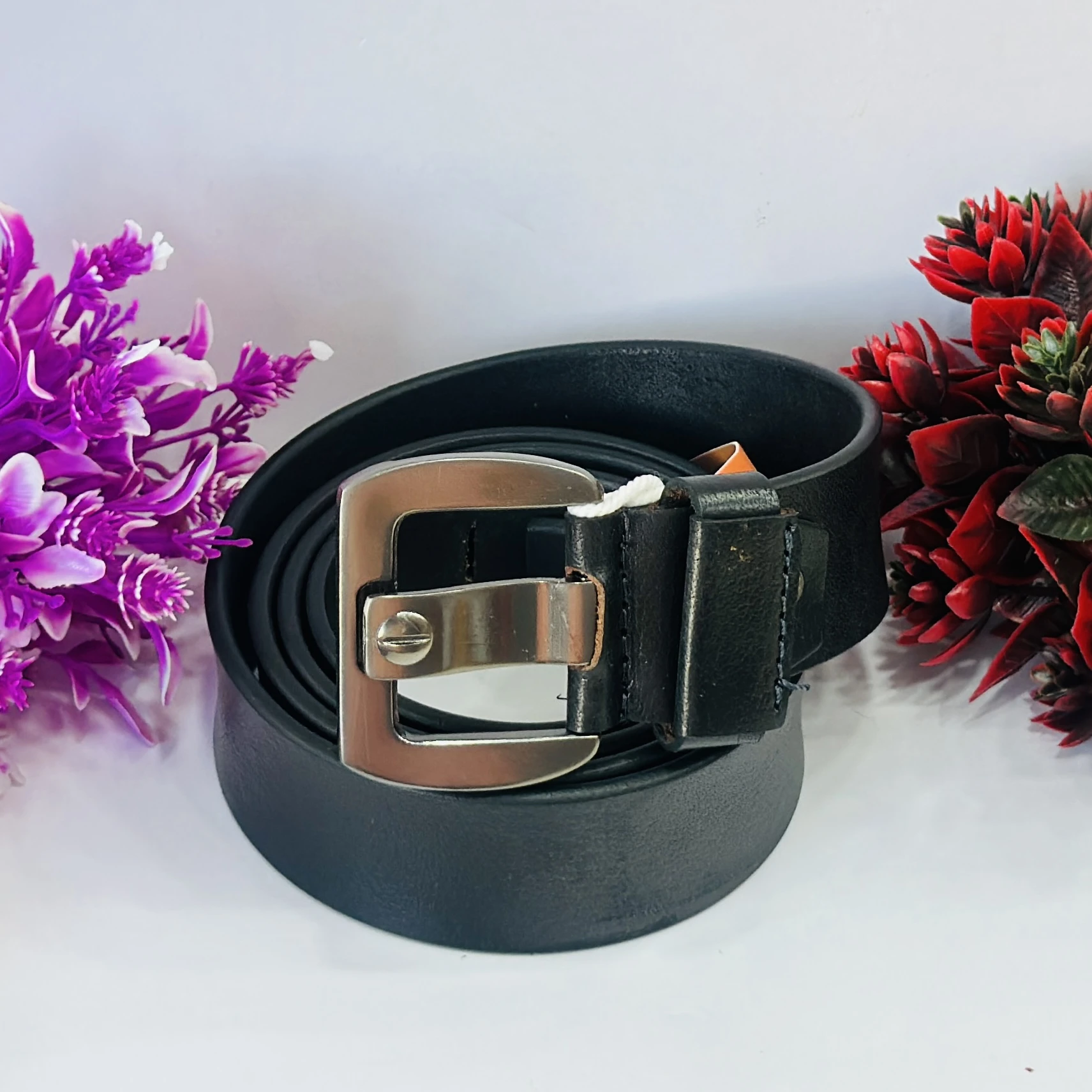 Black leather belt with a silver-tone buckle.
