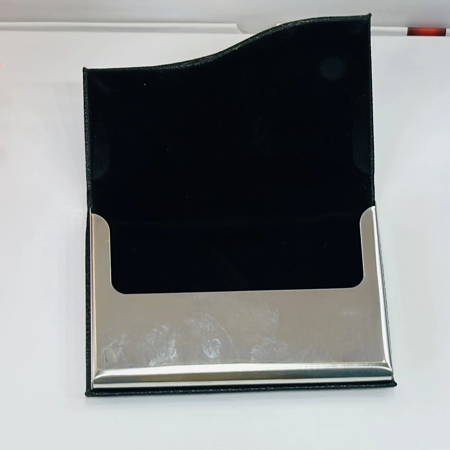 black faux leather and metal business card holder.