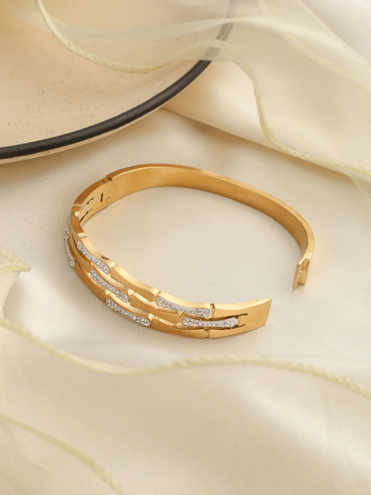 Gold plated bangle bracelet styled with clear rhinestones.
