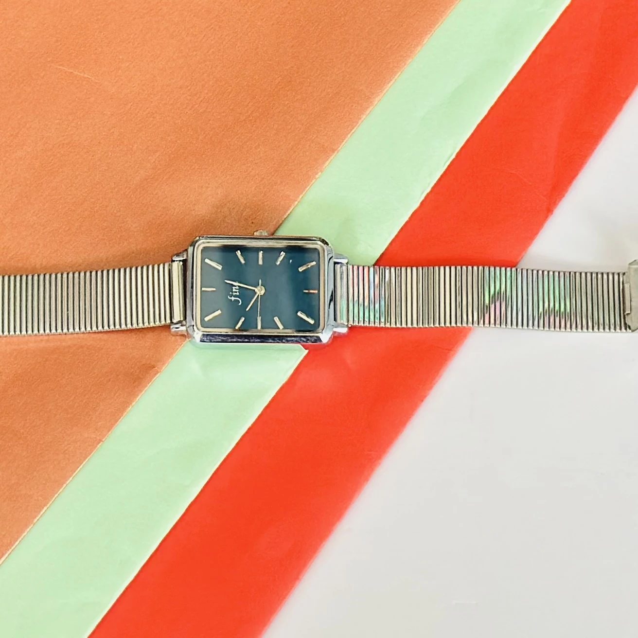 Rectangular Dial analog watch with a mesh strap.