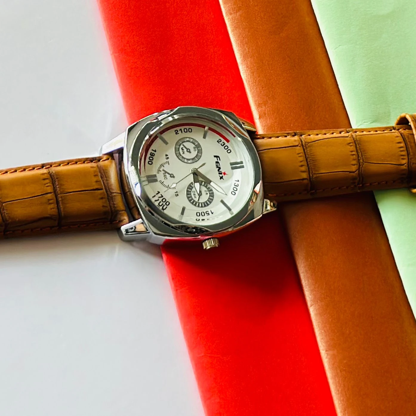 Round analog watch with a brown leather strap