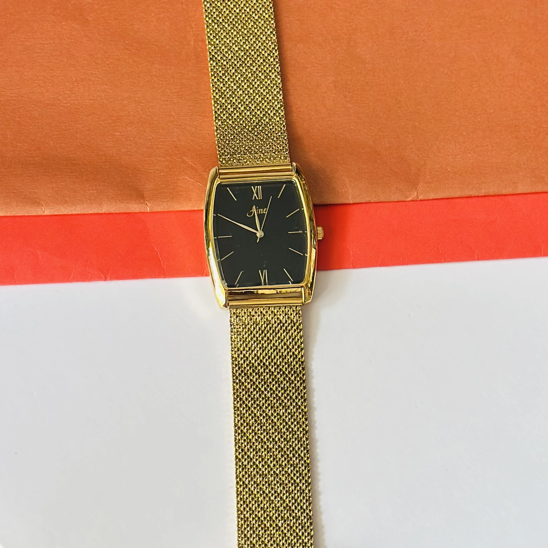 Aine vintage-style gold-tone rectangular quartz mesh watch with a black dial.