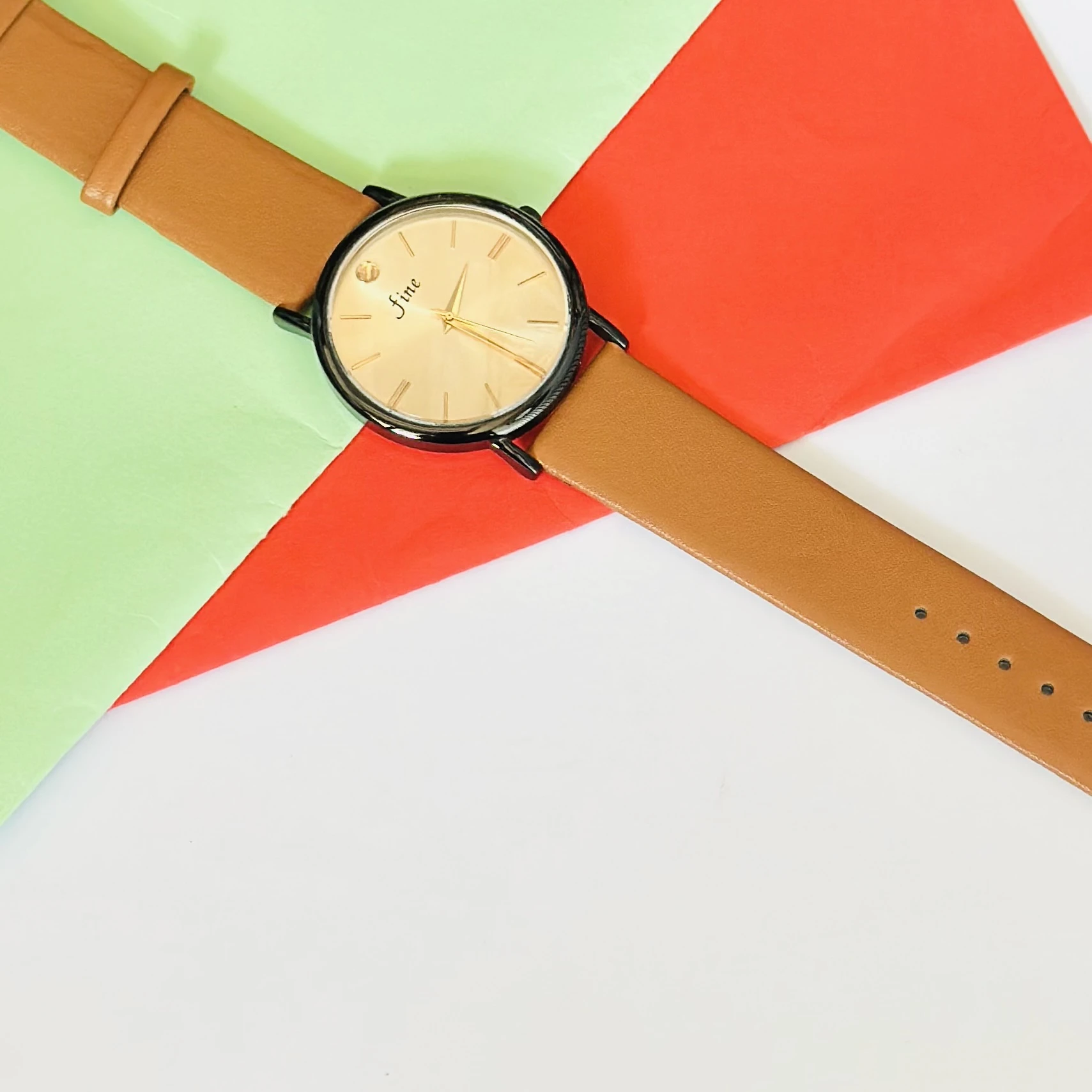 Analog wristwatch with a gold-tone case and a brown leather strap.