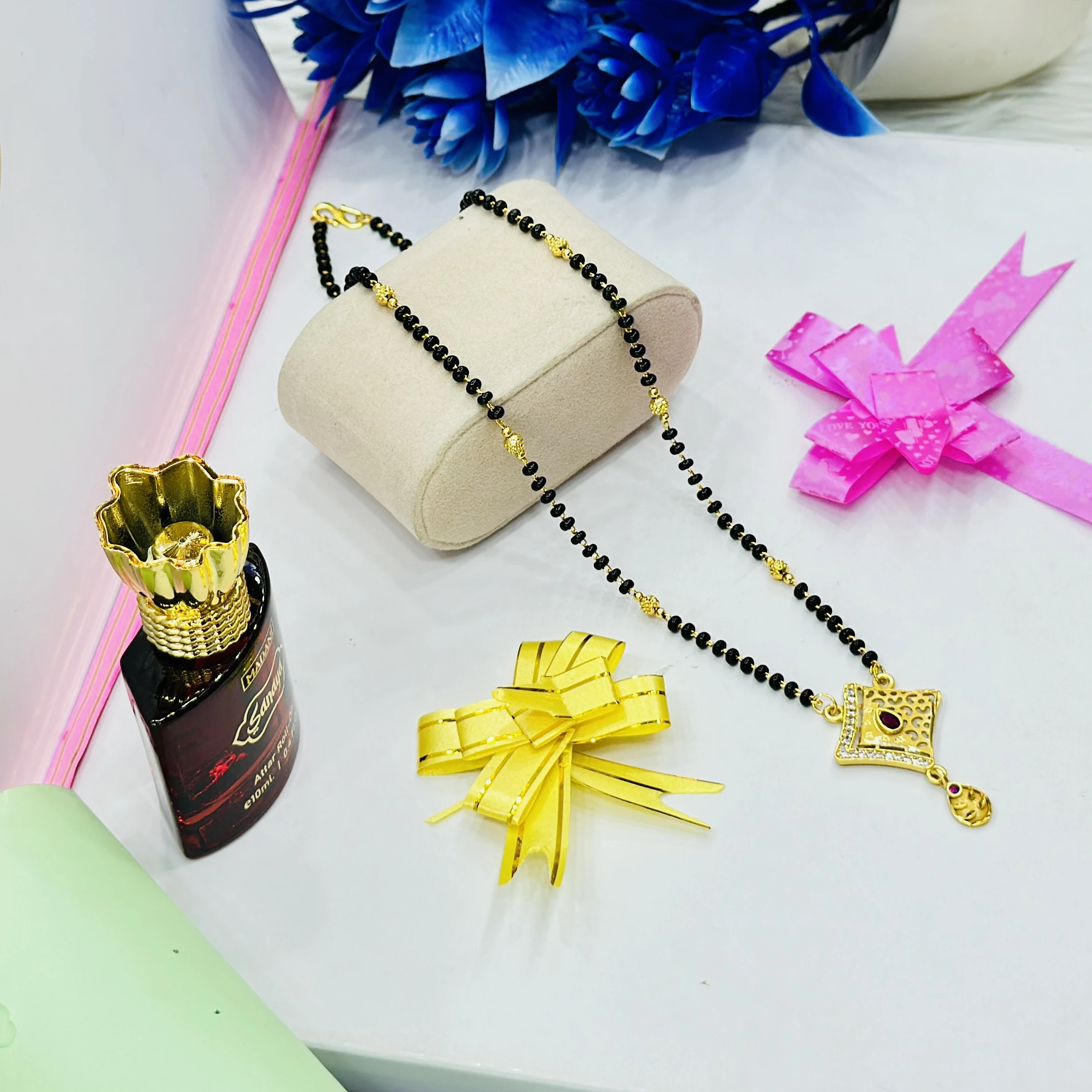 Gold plated mangalsutra features a designer pendant and black beaded chain.