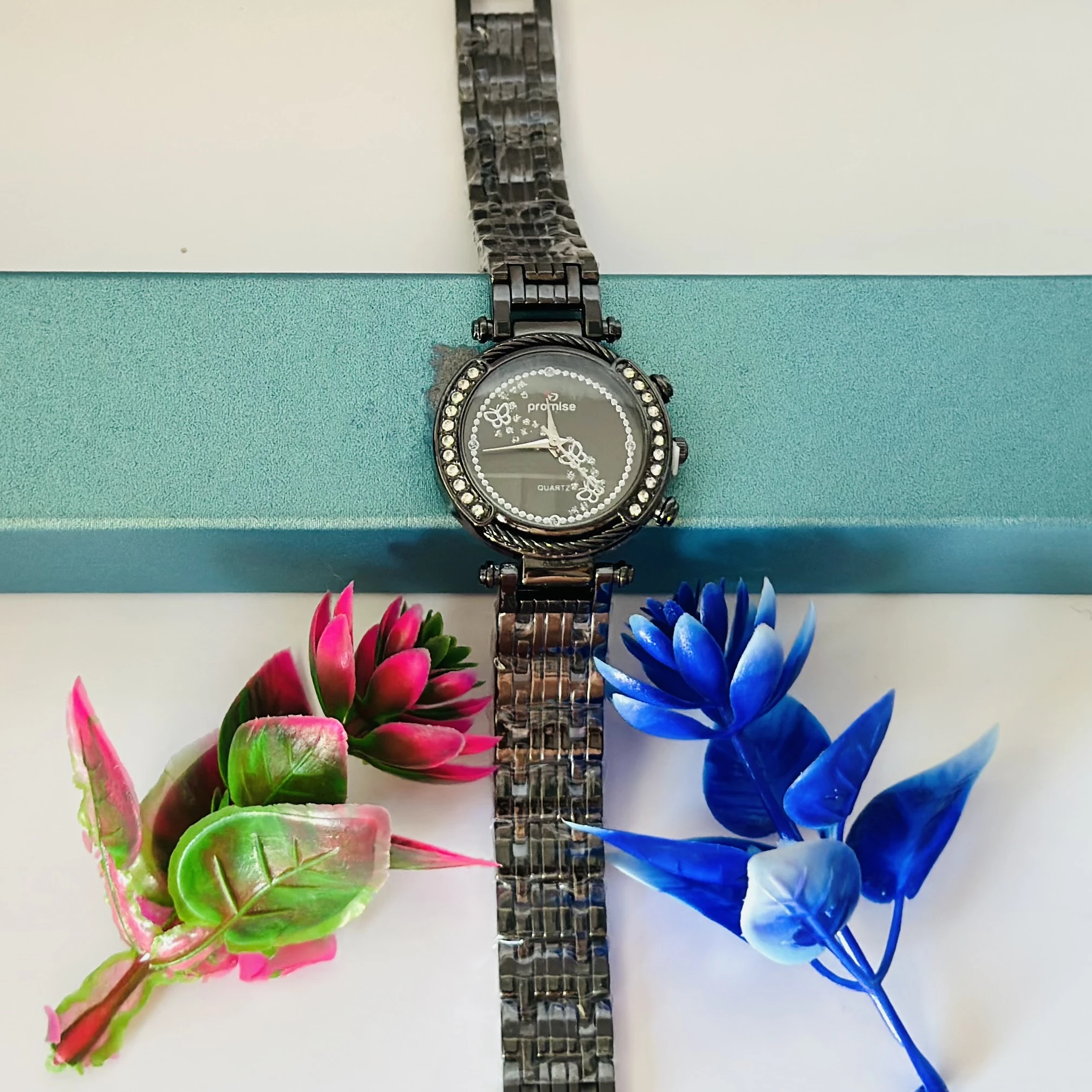 Quartz watch with a black metal band and a rhinestone-studded bezel.