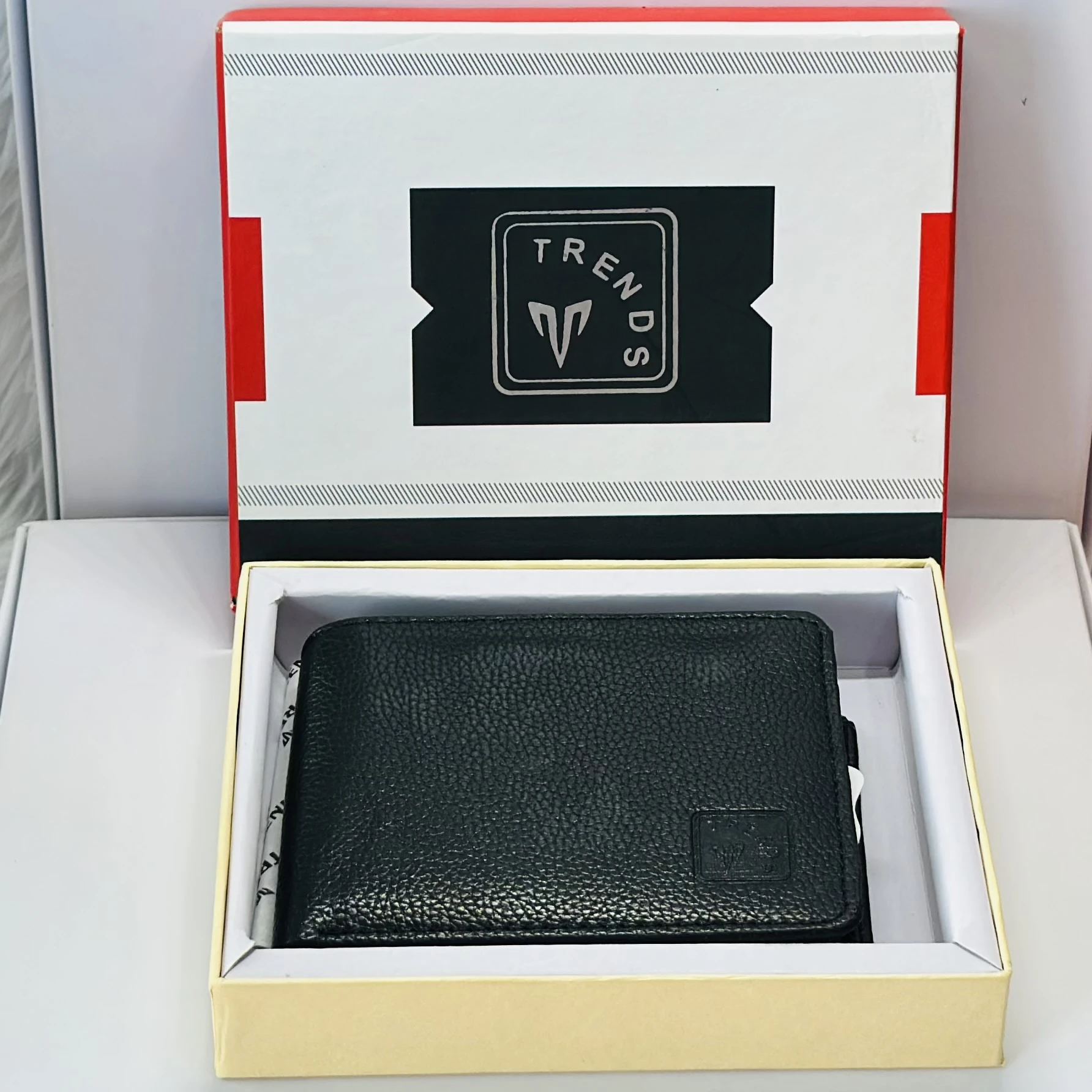 Black leather bifold wallet with a "Trends" logo.