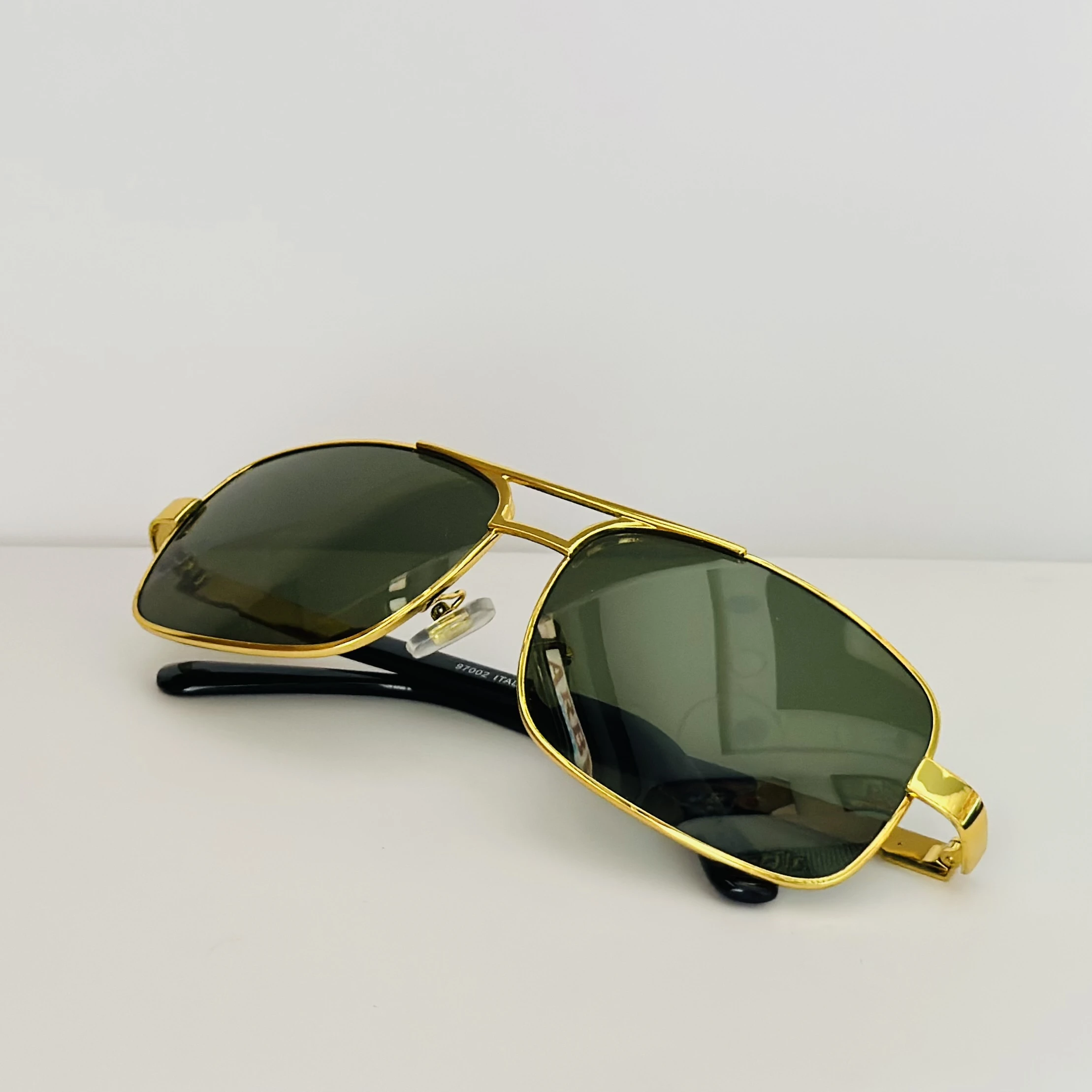 Gold aviator-style sunglasses with green lenses.