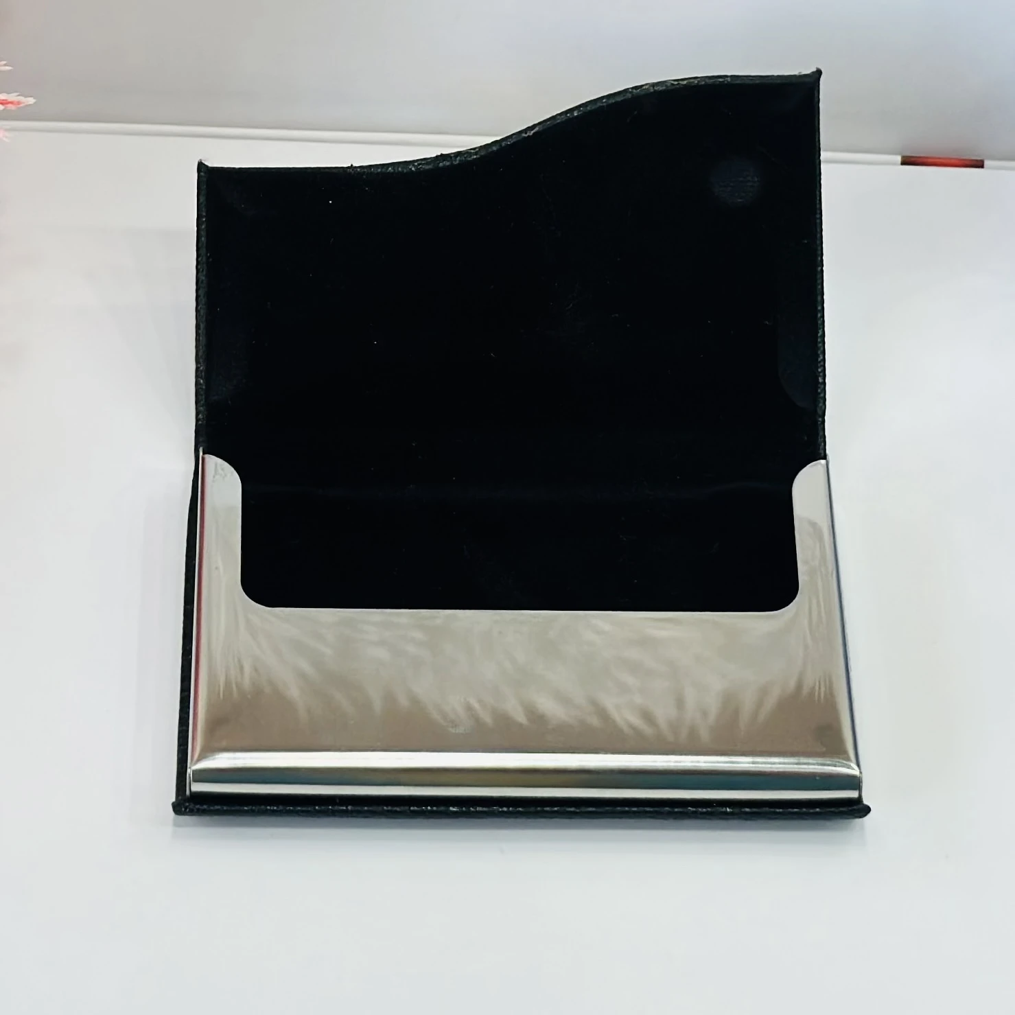 black faux leather and metal business card holder.
