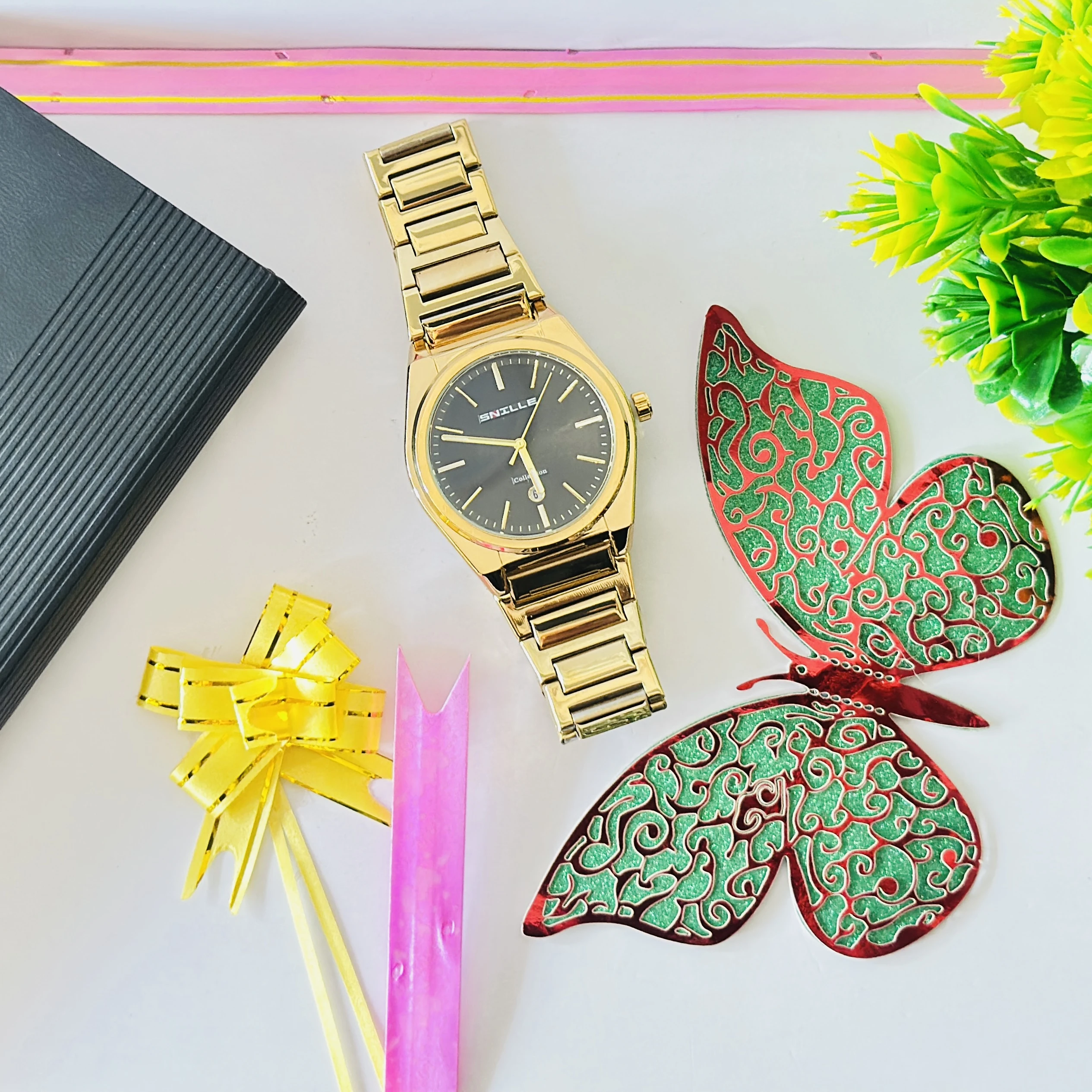 Snille brand gold-toned analog watch with a black dial and metal strap.