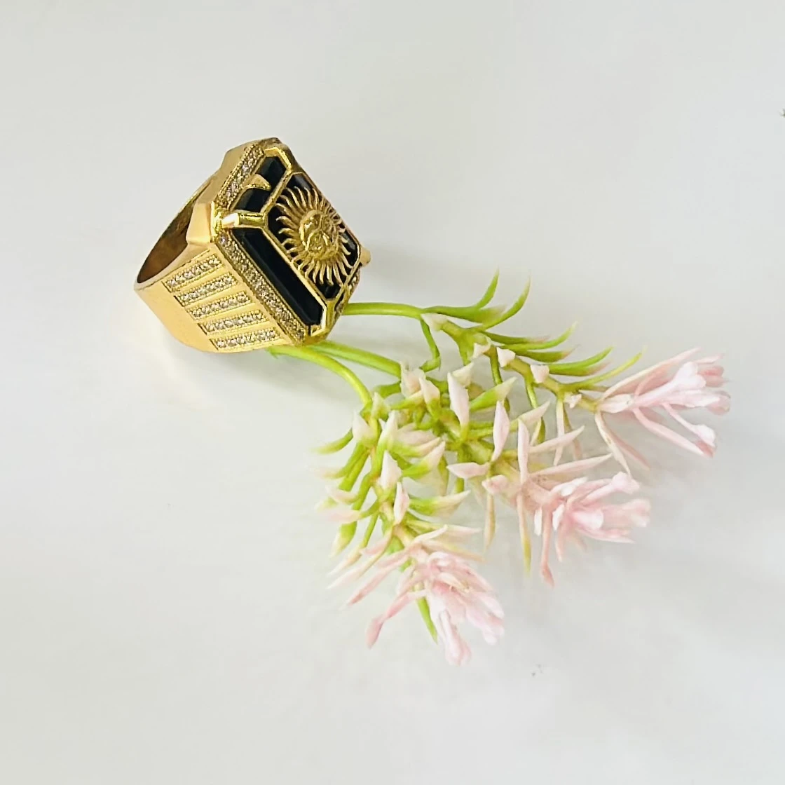 Gold plated men's ring featuring a sun emblem on a black background