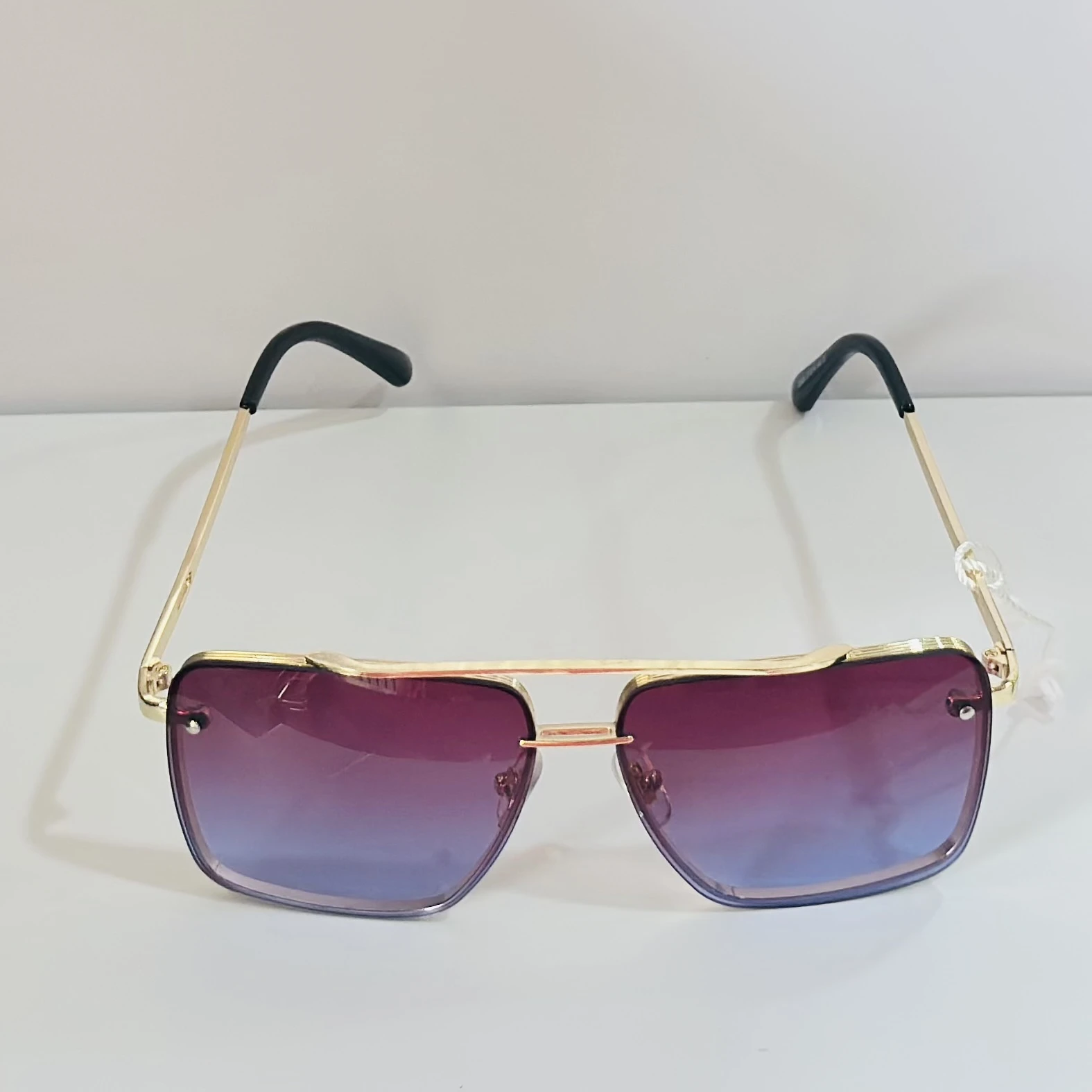 Sunglasses in a gold-tone metal frame with gradient lenses.