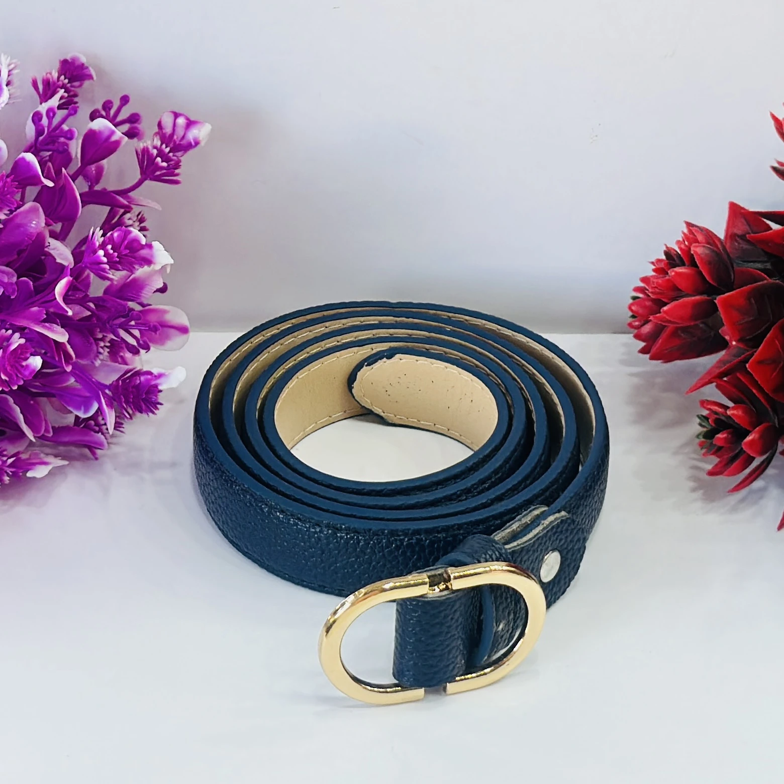 Blue women's belt with a gold-tone oval buckle.