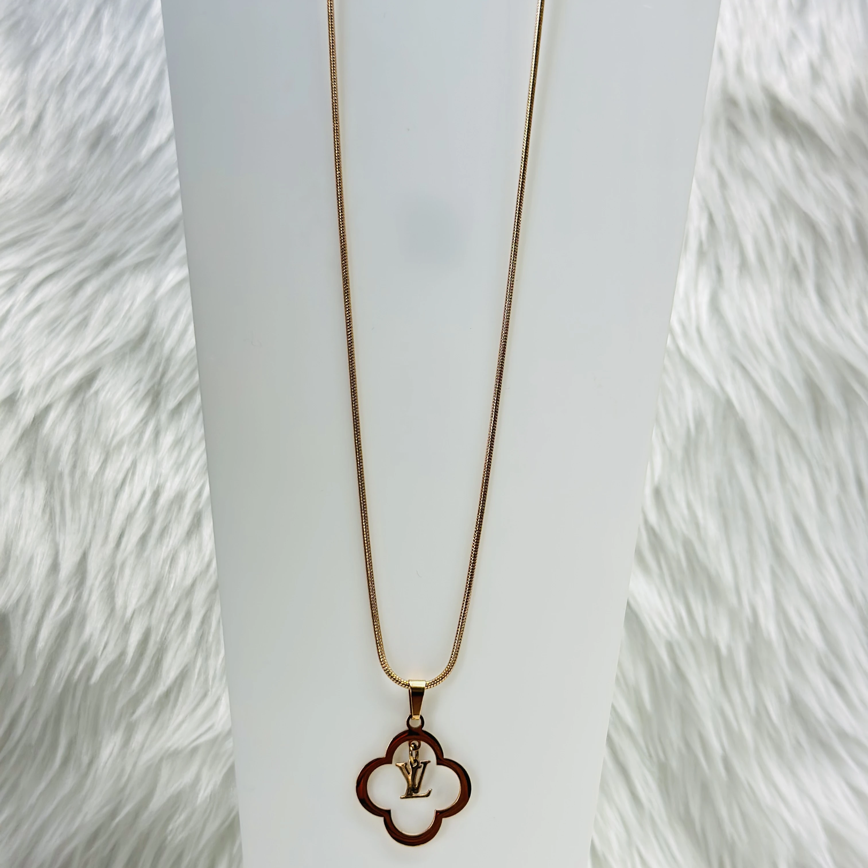 gold-plated pendant with a quatrefoil pendant featuring the 'LV' logo