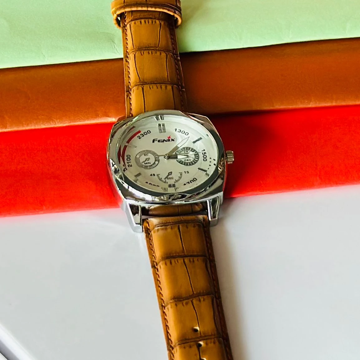 Round analog watch with a brown leather strap