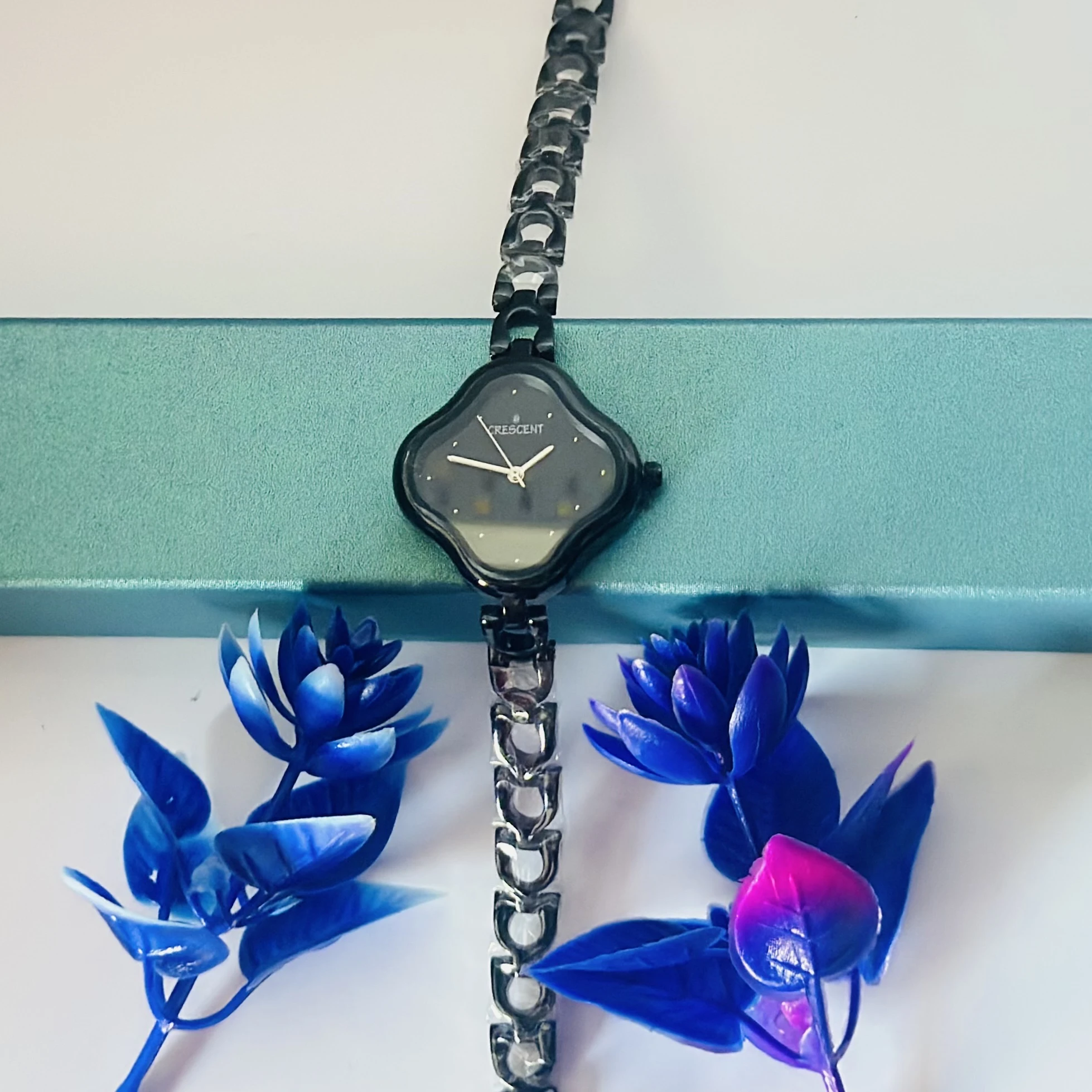 Black dial analog watch for women with a black bi-metal strap.