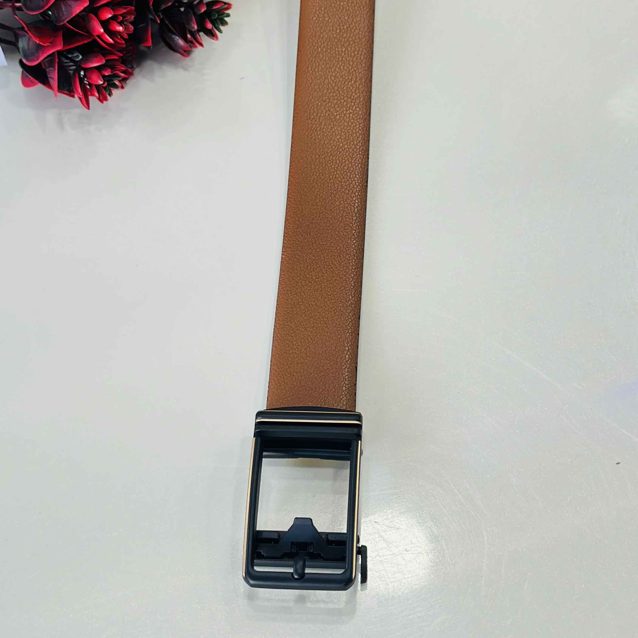 Tan and black reversible formal belt with an auto-lock buckle.