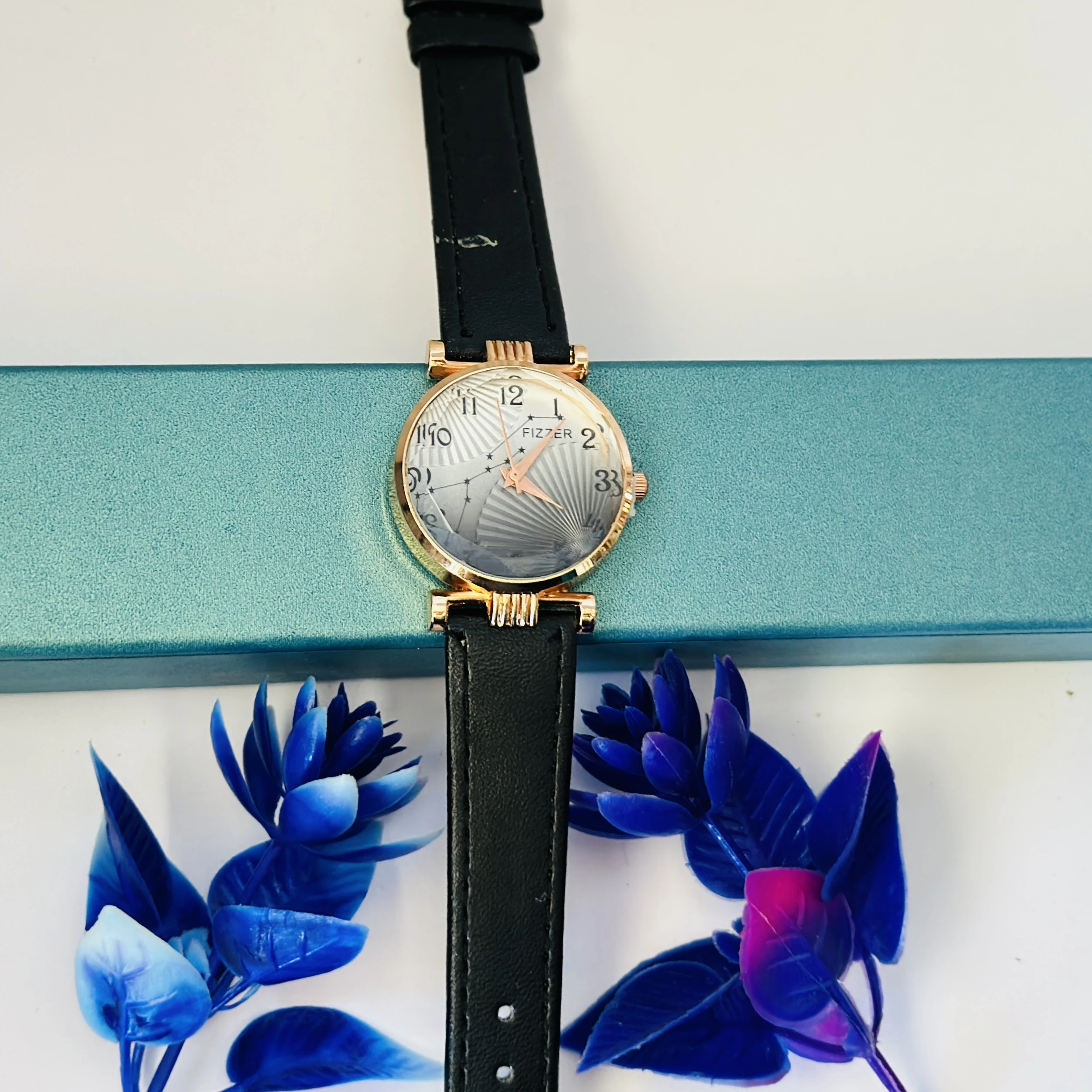 women's analog watch with a black leather strap and a rose gold-toned case.