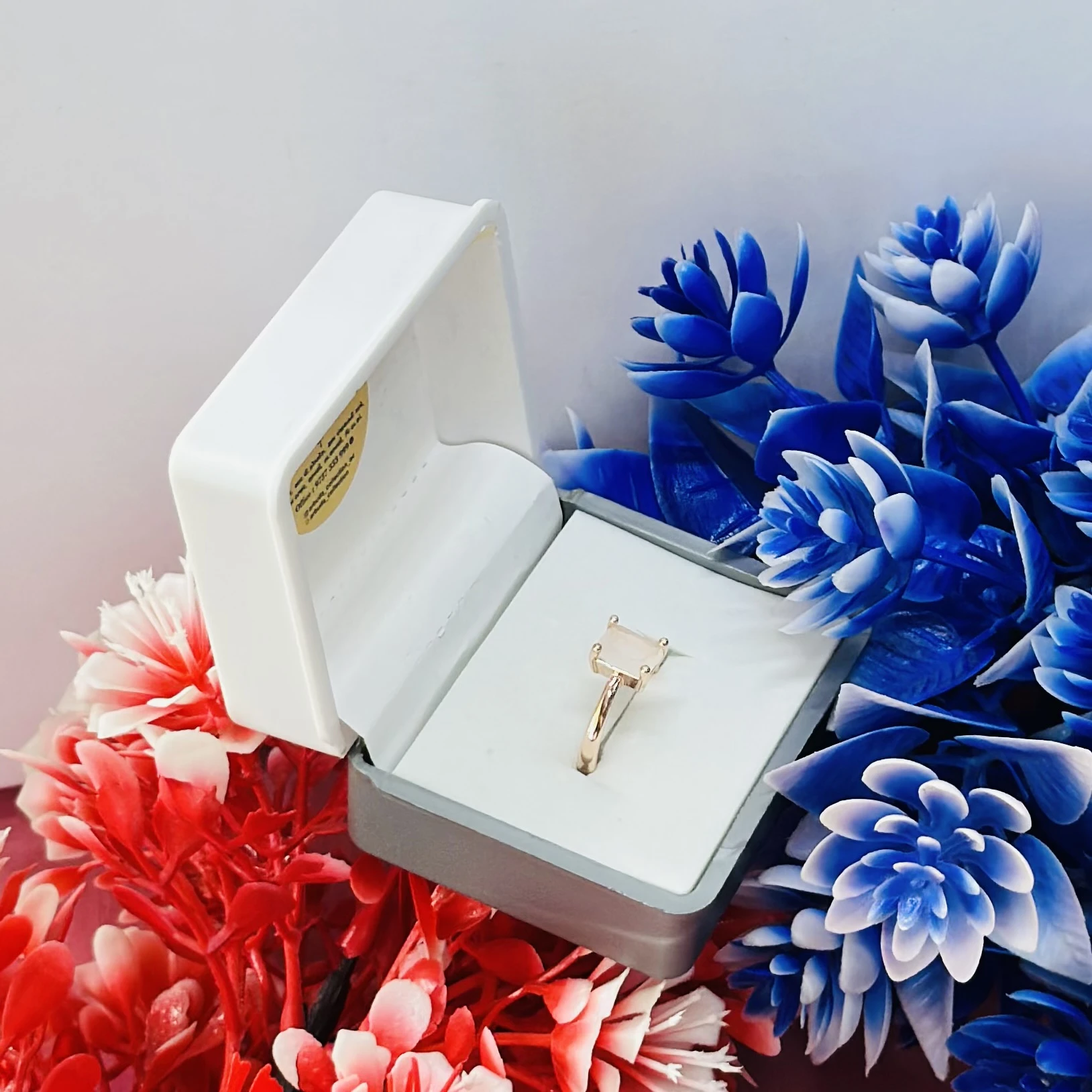 Rose gold-toned ring with a square-cut white stone.