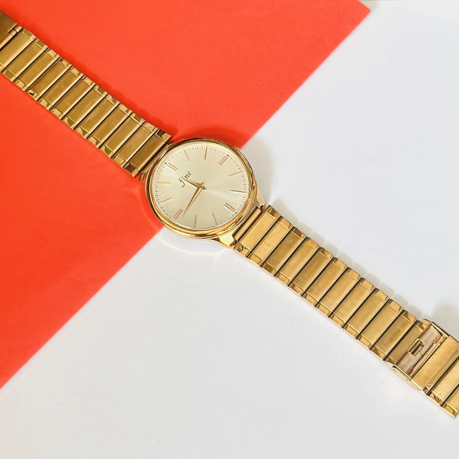Gold toned analog watch with a stainless steel strap