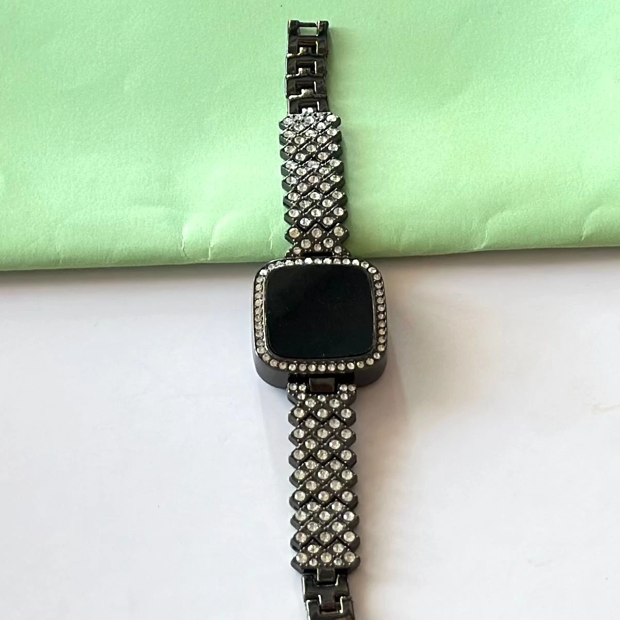 black-toned digital watch with an embellished rhinestone bracelet strap.